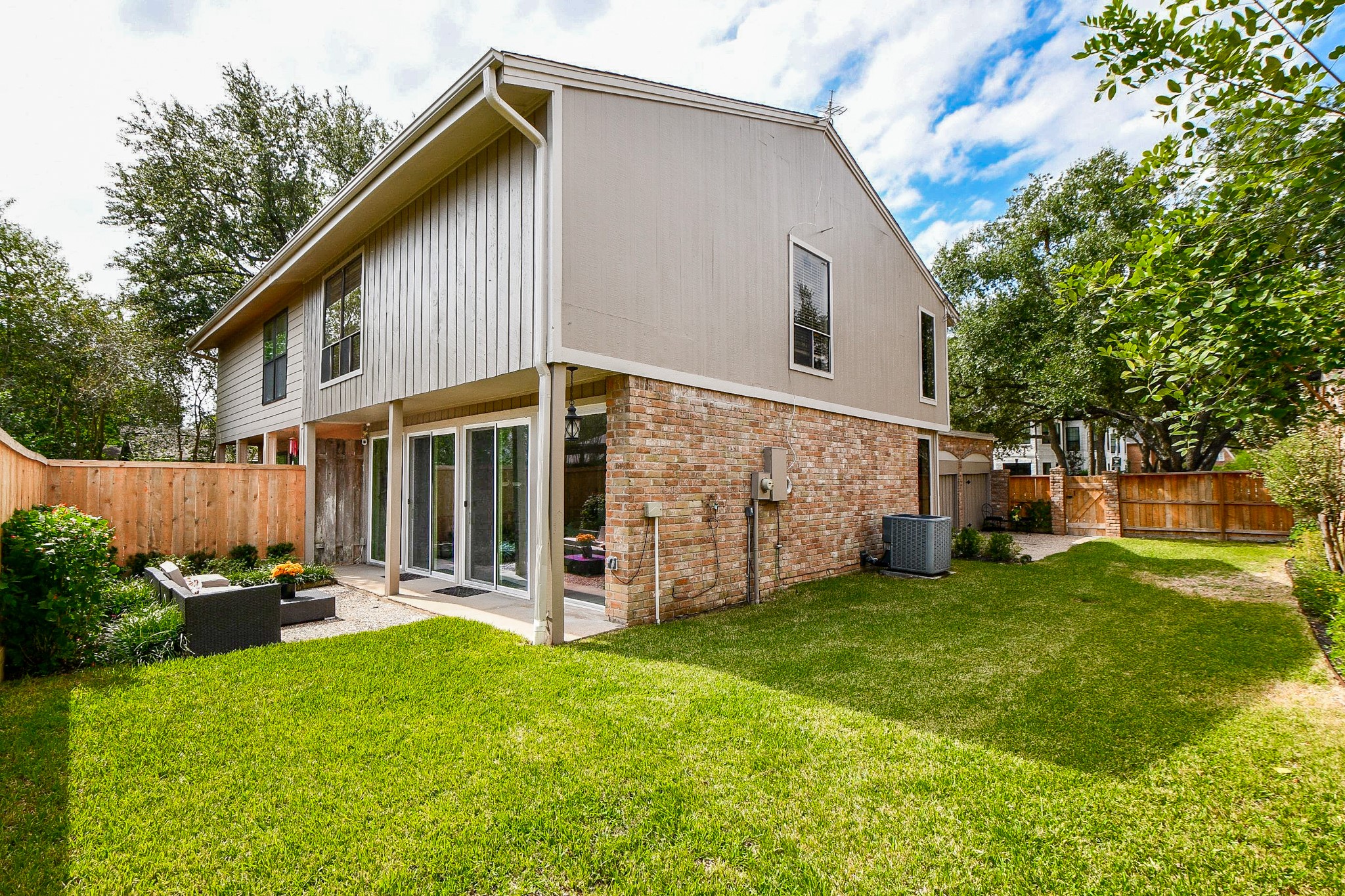 The L-shaped lot wraps around the home, adding side-yard space and a gravel sitting area.