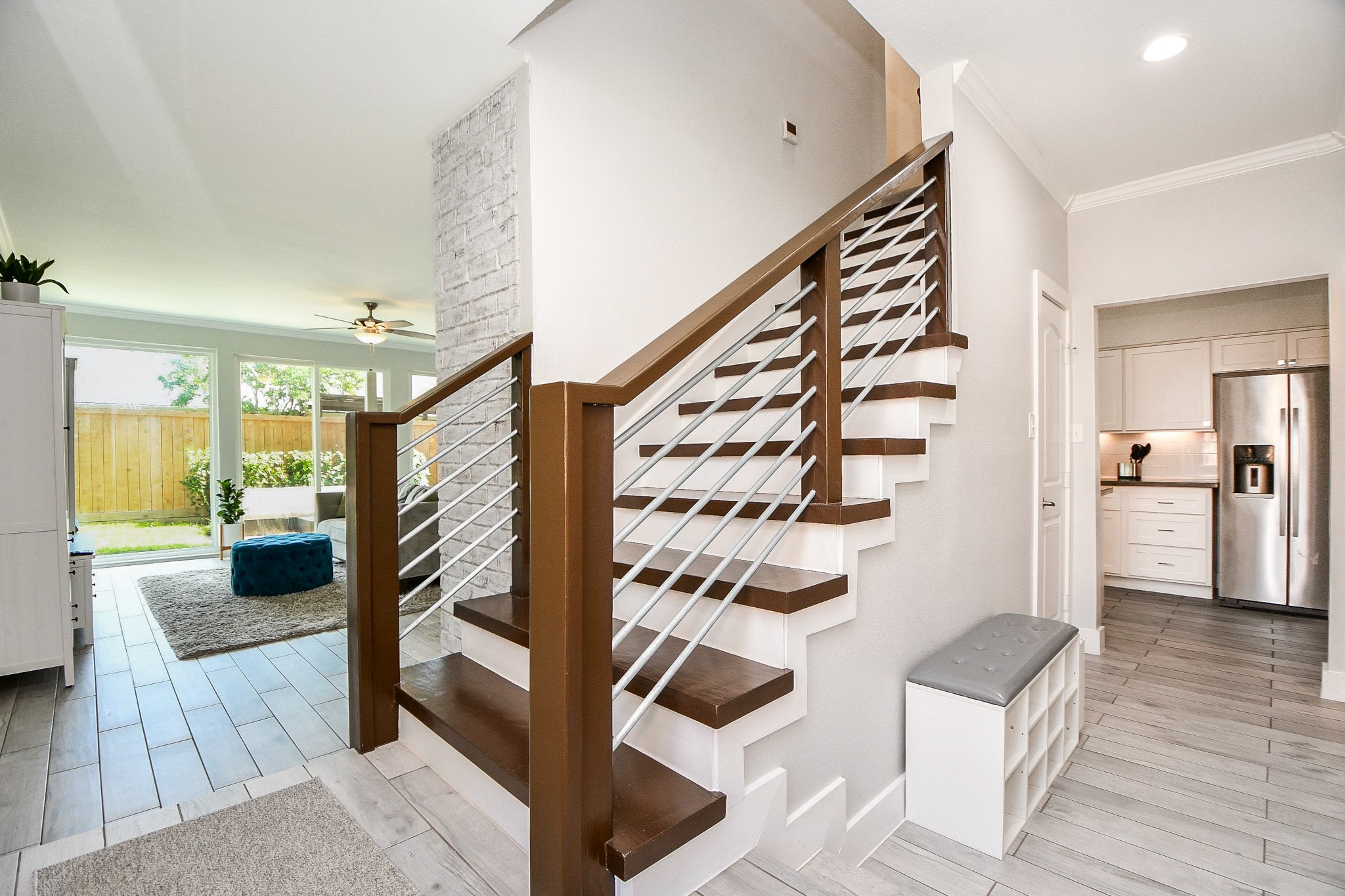 The modern staircase has rich wood treads and horizontal cable-style railings.