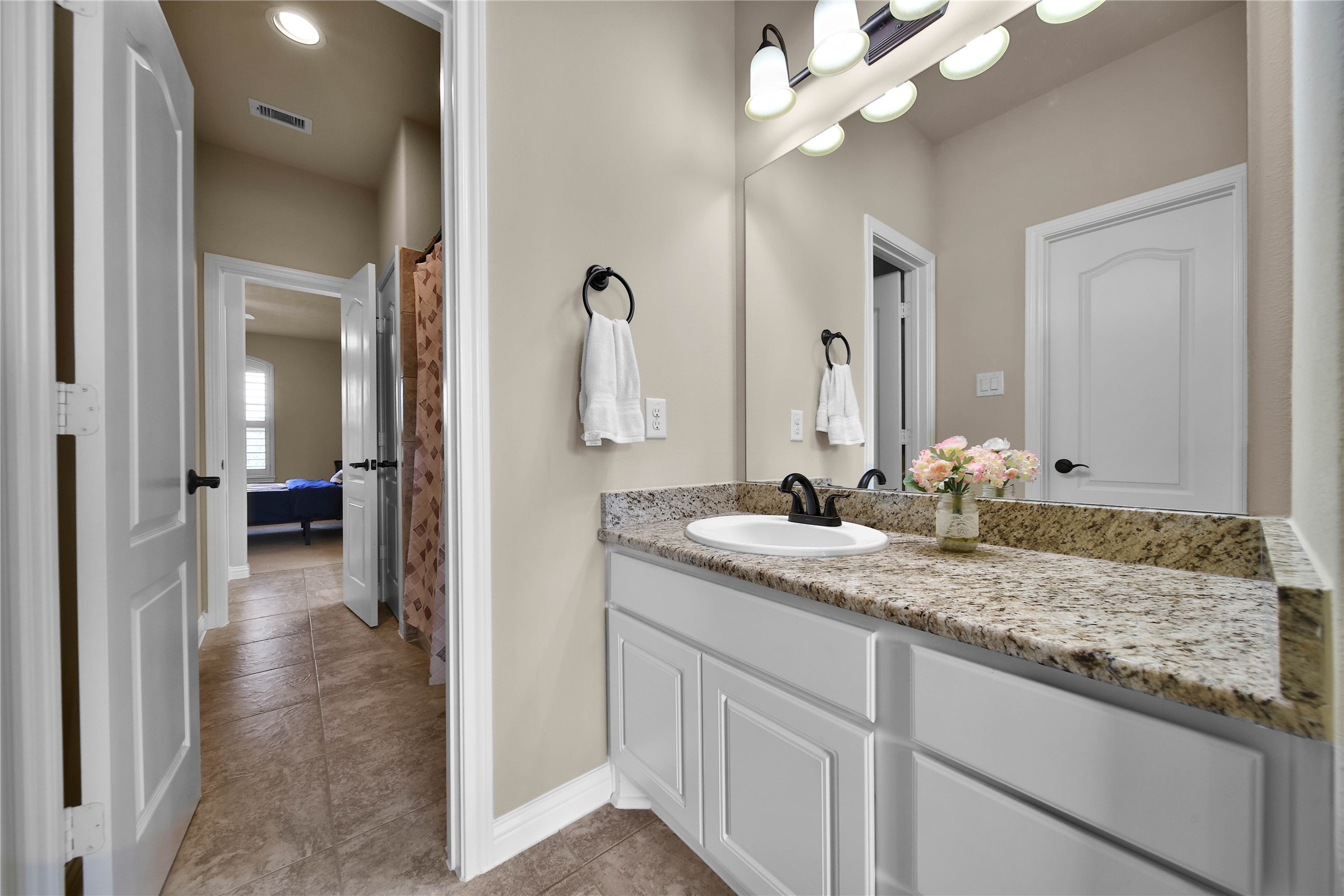 Bedrooms 2 and 3 each feature a private vanity area and are thoughtfully connected by a shared Jack-and-Jill style bathroom for added convenience and functionality.