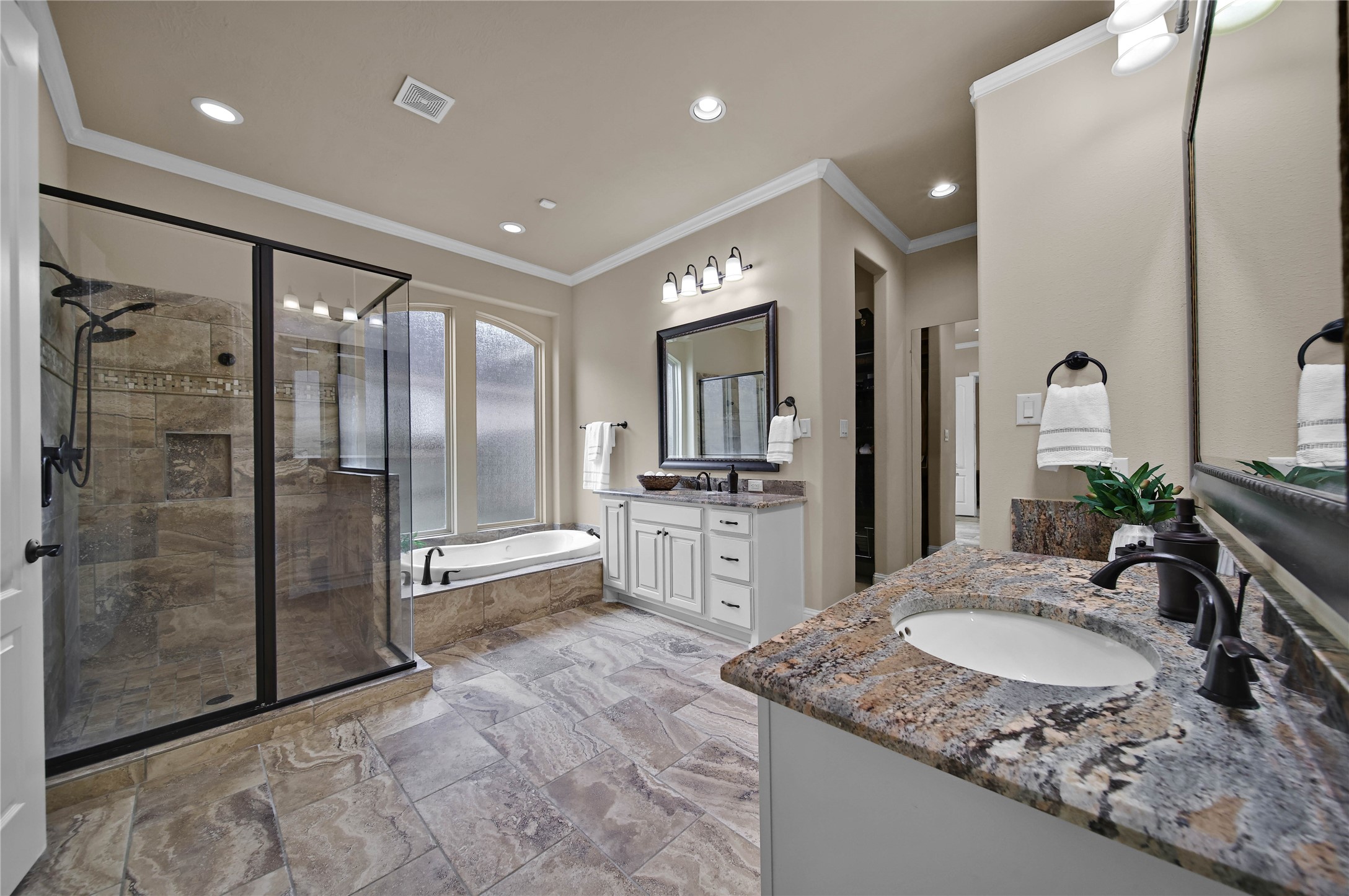 Neutral colors and natural materials add subtle elegance to the primary bath.The space is thoughtfully designed with a dedicated dressing mirror and two spacious closets featuring custom built-ins for exceptional organization and convenience.