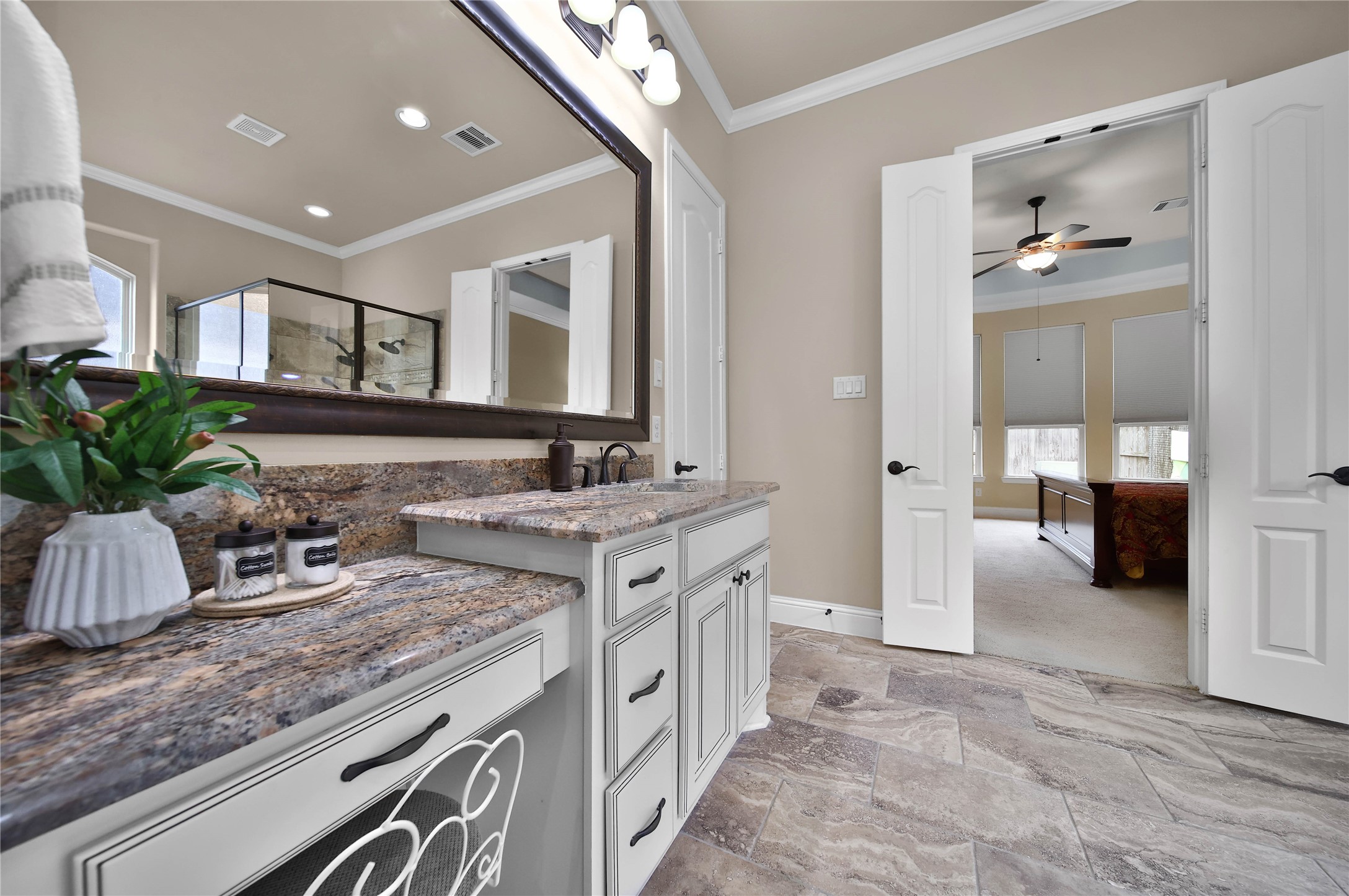 The primary bath offers dual sinks and a convenient sit-down vanity area, providing both functionality and a touch of luxury for your daily routine.