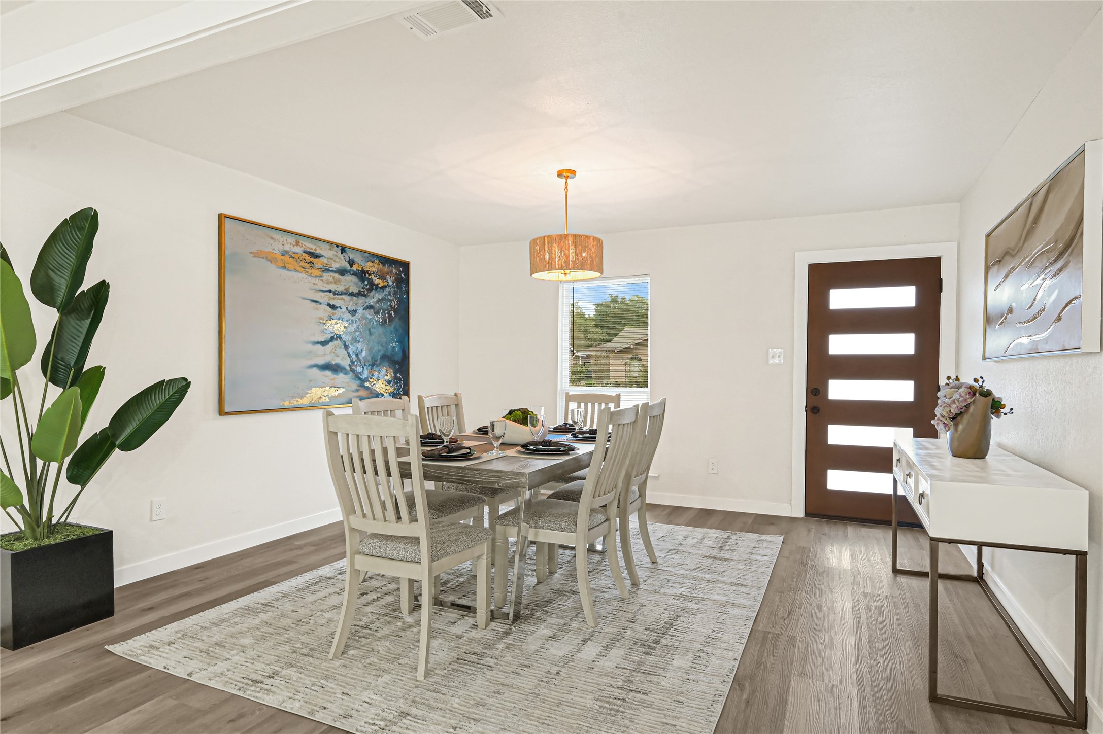 Inviting dining area featuring modern lighting, updated flooring, and plenty of natural light.