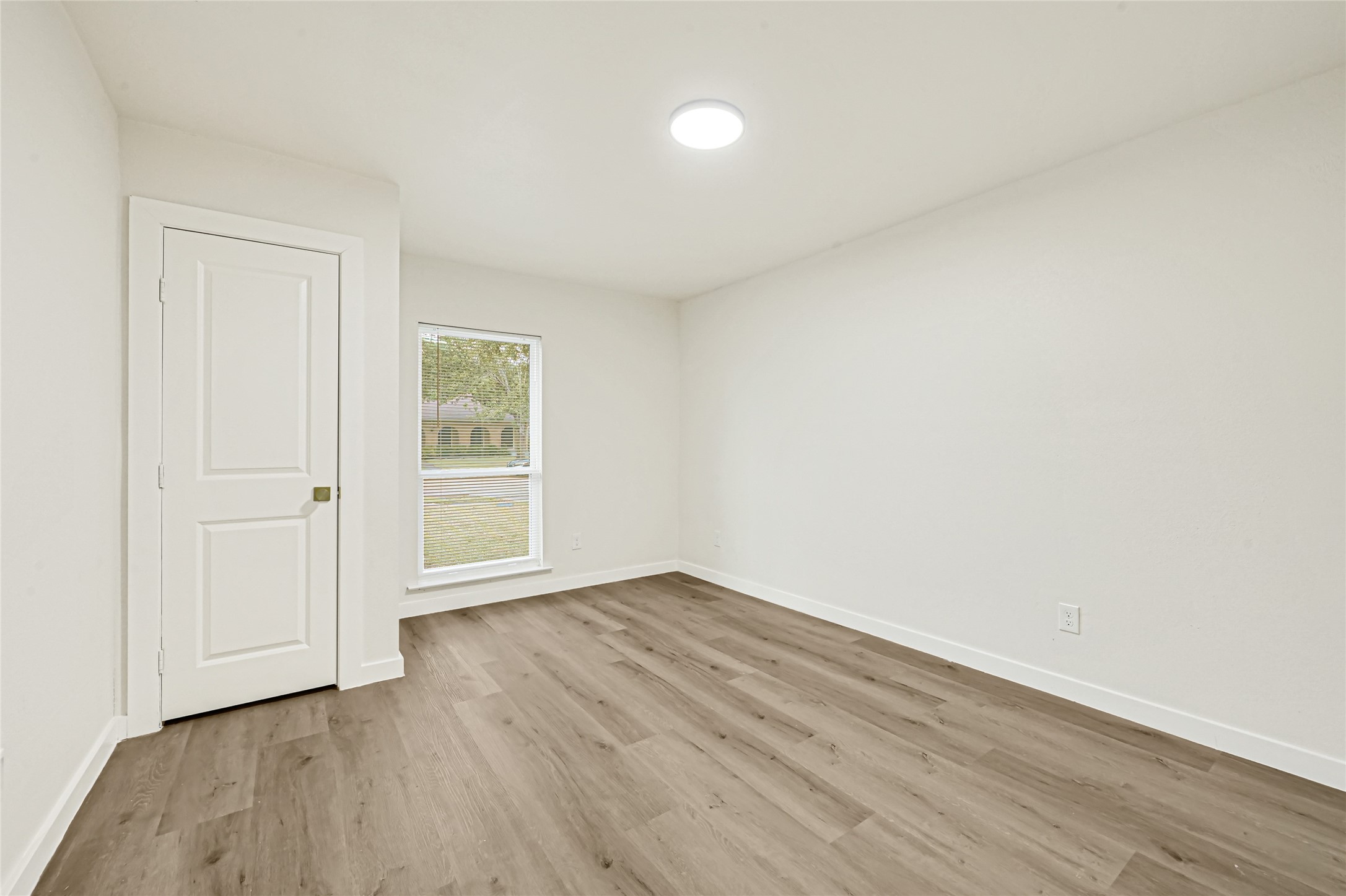 Bright second bedroom with updated flooring and modern finishes.