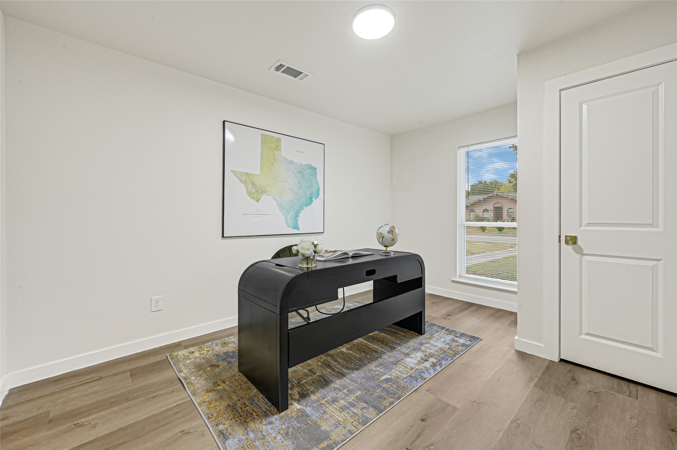 Versatile bedroom currently staged as a home office, offering the flexibility to create a workspace, guest room, or additional bedroom to suit your needs.
