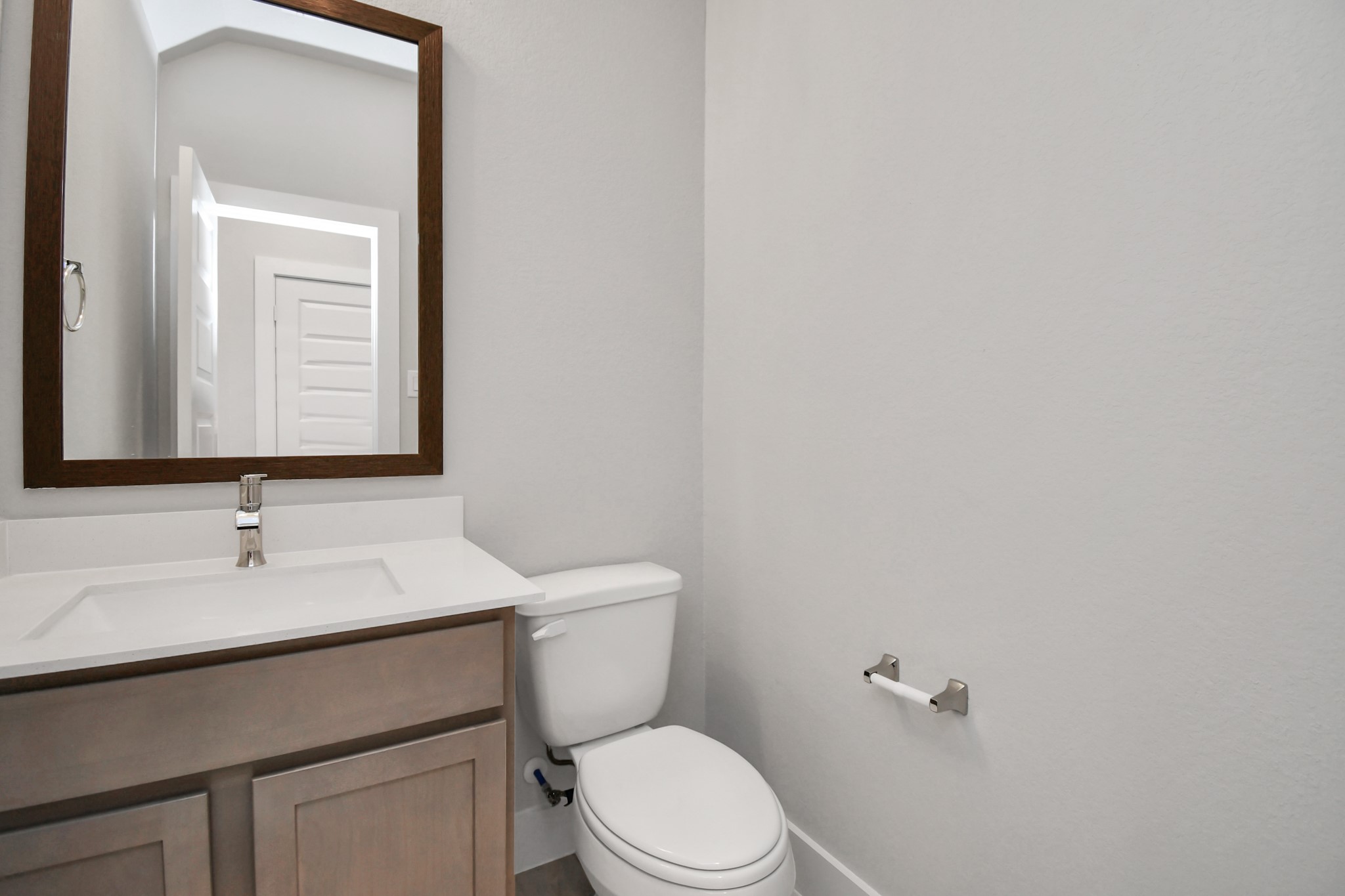 Delightful half bathroom featuring a sophisticated 5-panel door, upgraded sink, contemporary hardware, and bright recessed lights. Sample photo of completed home with similar floor plan. Actual colors and selections may vary. Delightful half bathroom featuring a sophisticated 5-panel door, upgraded sink, contemporary hardware, and bright recessed lights. Sample photo of completed home with similar floor plan. Actual colors and selections may vary.