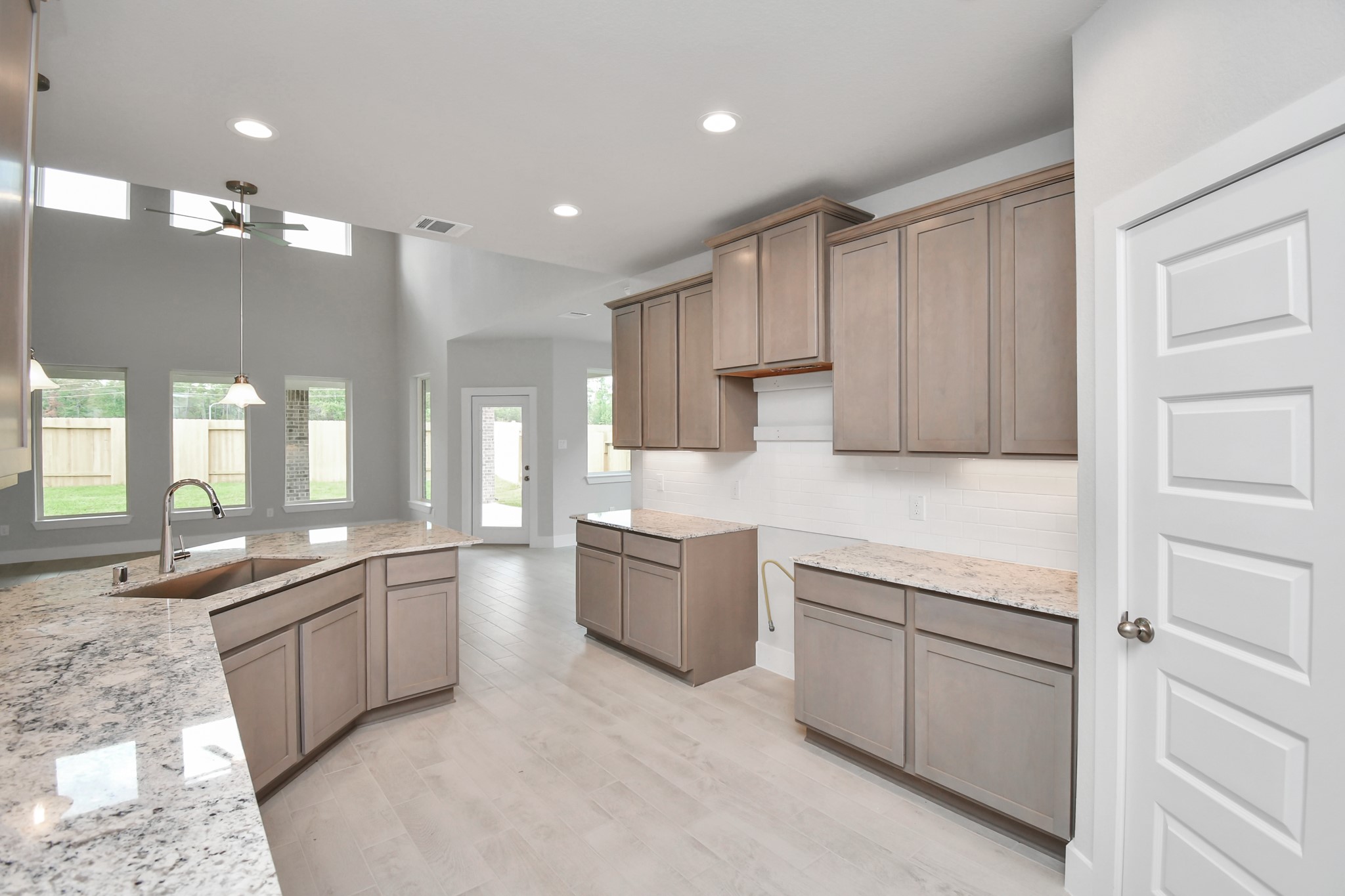 This kitchen is by far any chefs dream! This spacious kitchen features high ceilings, stained wood cabinets, granite countertop, SS appliances, modern tile backsplash, recessed lighting, and an extended counter space. Sample photo of completed home with similar floor plan. Actual colors and selections may vary. This kitchen is by far any chefs dream! This spacious kitchen features high ceilings, stained wood cabinets, granite countertop, SS appliances, modern tile backsplash, recessed lighting, and an extended counter space. Sample photo of completed home with similar floor plan. Actual colors and selections may vary.