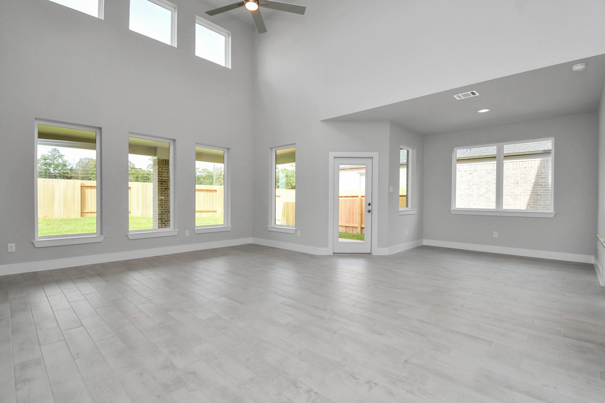 Gather the family and guests together in your lovely living room! Featuring soaring high ceilings, recessed lighting, ceiling fan, custom paint, gorgeous floors, and large windows that provide plenty of natural lighting throughout the day. Sample photo of completed home with similar floor plan. Actual colors and selections may vary.