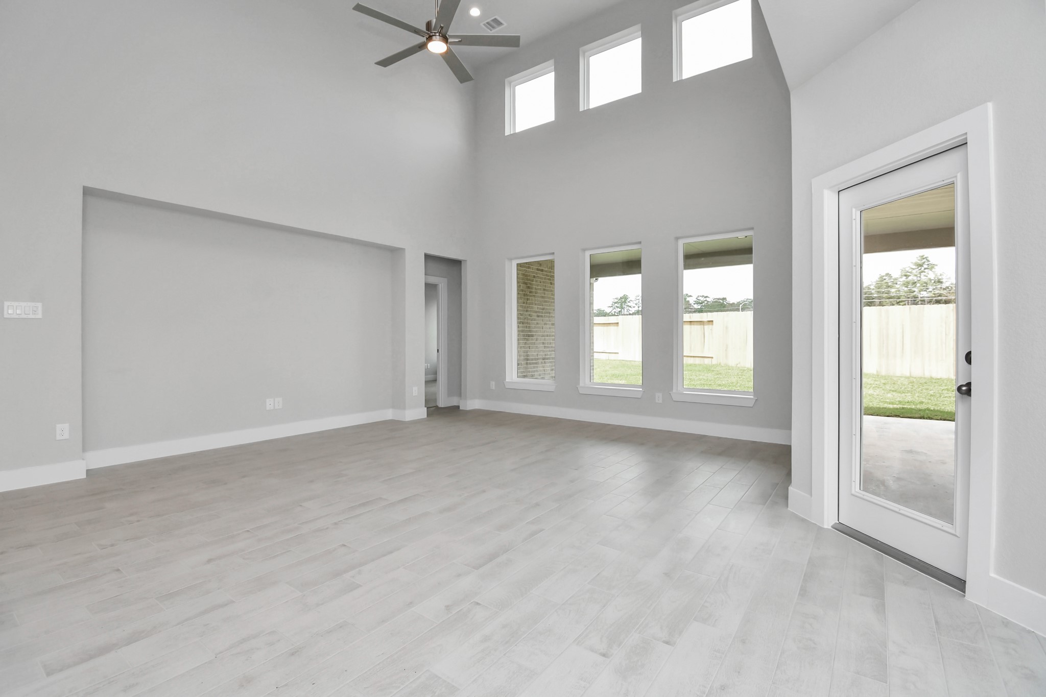 Welcome family and guests to your charming living room! With its high ceilings, recessed lighting, ceiling fan, custom paint, beautiful flooring, and large windows that let in abundant natural light, this room is perfect for gatherings. Sample photo of completed home with similar floor plan. Actual colors and selections may vary.
