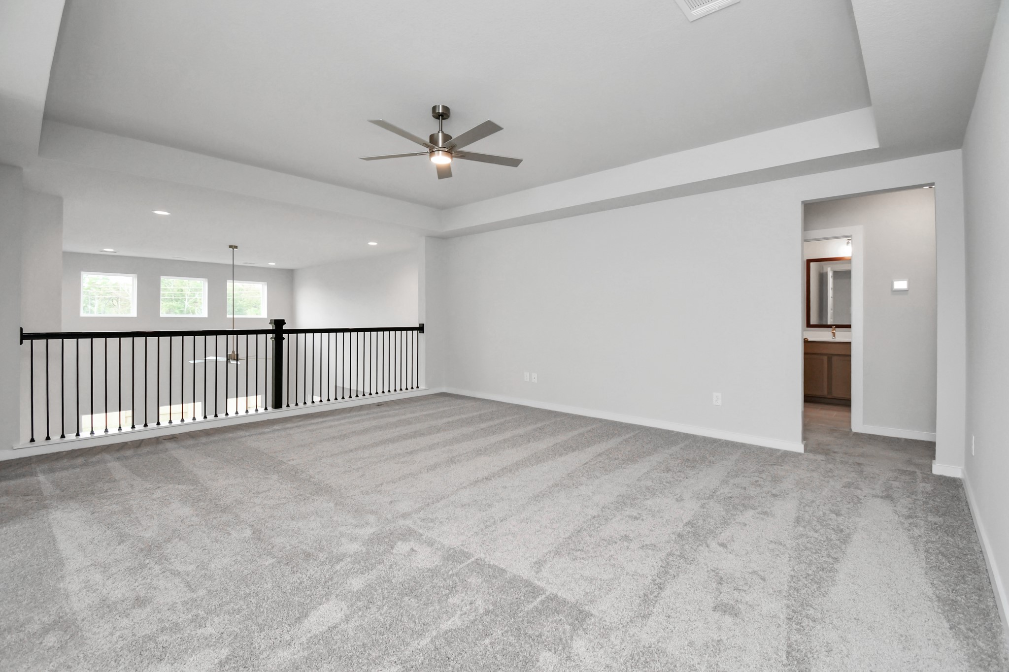 Discover a haven of leisure in this fantastic game room! Whether you're seeking a casual hangout or an adult gaming retreat, this space has it all. Enjoy the luxurious feel of plush carpet underfoot, the expansive ambiance of high ceilings, custom paint that adds a touch of personality, and windows that flood the room with refreshing natural light. Sample photo of completed home with similar floor plan. Actual colors and selections may vary.