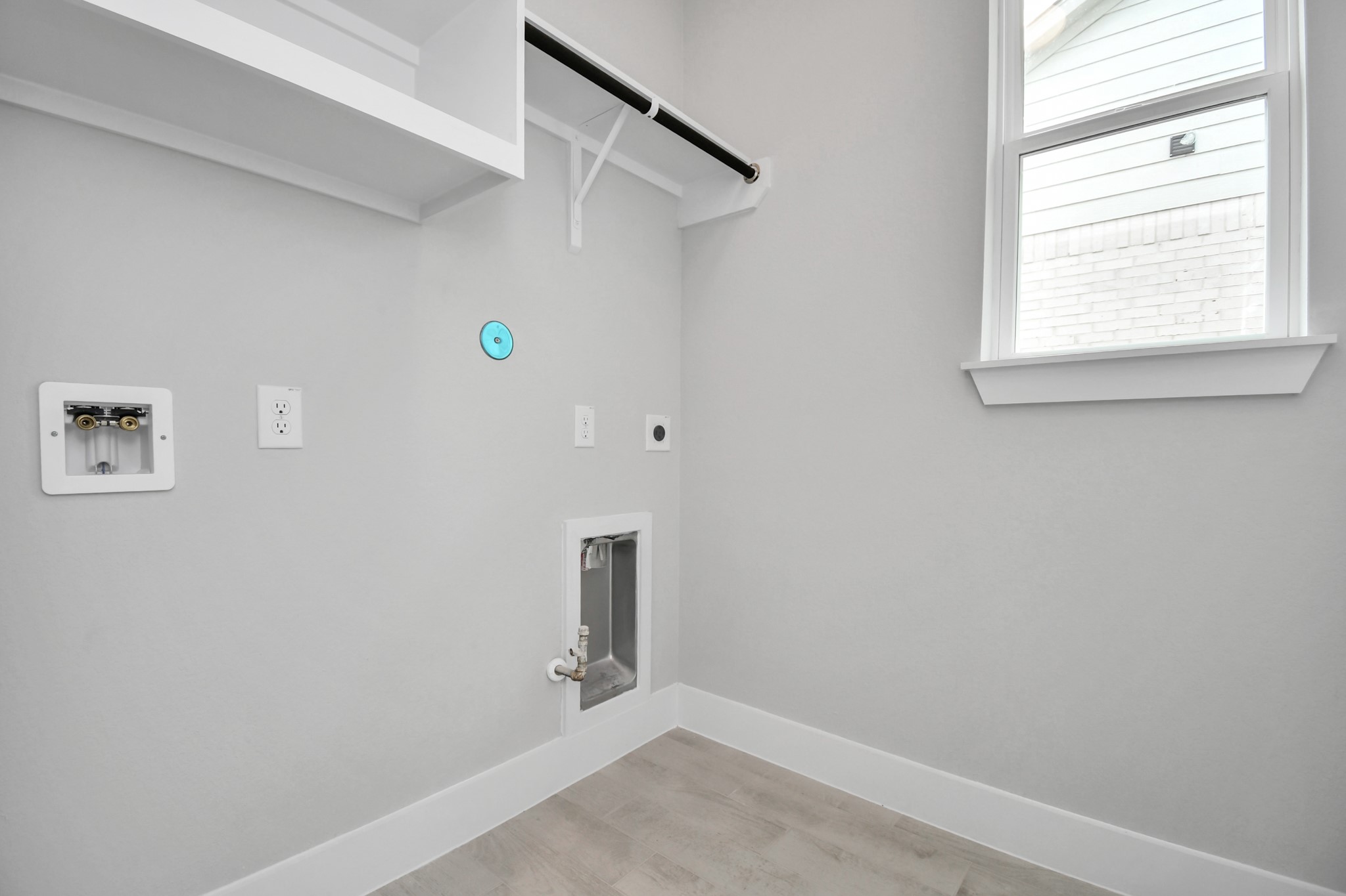 A perfect blend of functionality and comfort. Capture the essence of easy living with a first-floor laundry room, thoughtfully equipped with shelving for effortless organization. Both electric and gas connections available. Sample photo of completed home with similar floor plan. Actual colors and selections may vary.
