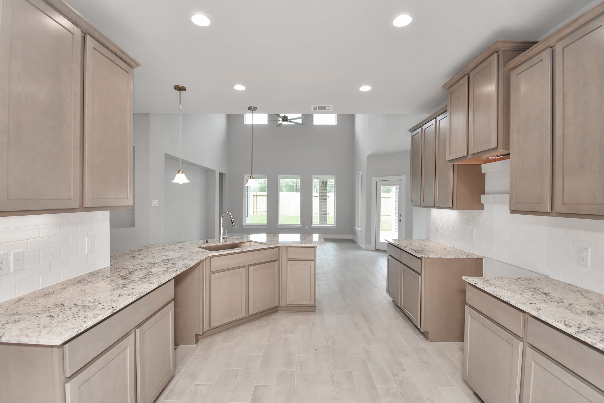 The kitchen is a culinary haven, featuring granite countertops, a tile backsplash, stainless steel appliances, 42 upper cabinets, and undercabinet lighting. Sample photo of completed home with similar floor plan. Actual colors and selections may vary. The kitchen is a culinary haven, featuring granite countertops, a tile backsplash, stainless steel appliances, 42 upper cabinets, and undercabinet lighting. Sample photo of completed home with similar floor plan. Actual colors and selections may vary.