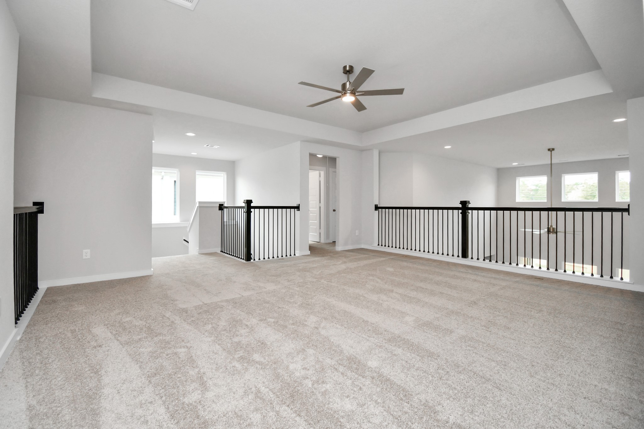 Ascend to relaxation in this fantastic game room! Ideal for both casual gatherings and adult gaming, it boasts plush carpet, lofty ceilings, custom paint, and ample windows for abundant natural light. Sample photo of completed home with similar floor plan. Actual colors and selections may vary.