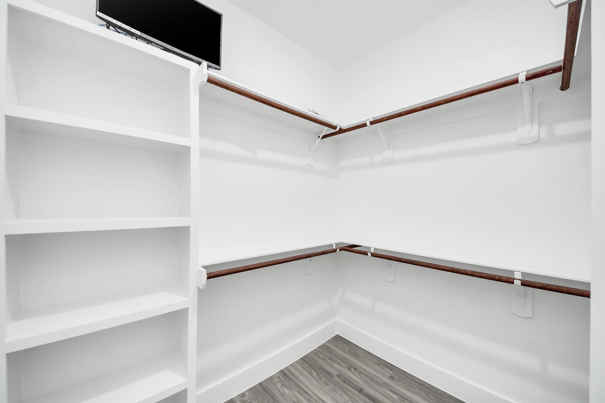 Spacious walk-in closet featuring built-in shelving and ample hanging space, perfect for organized storage.