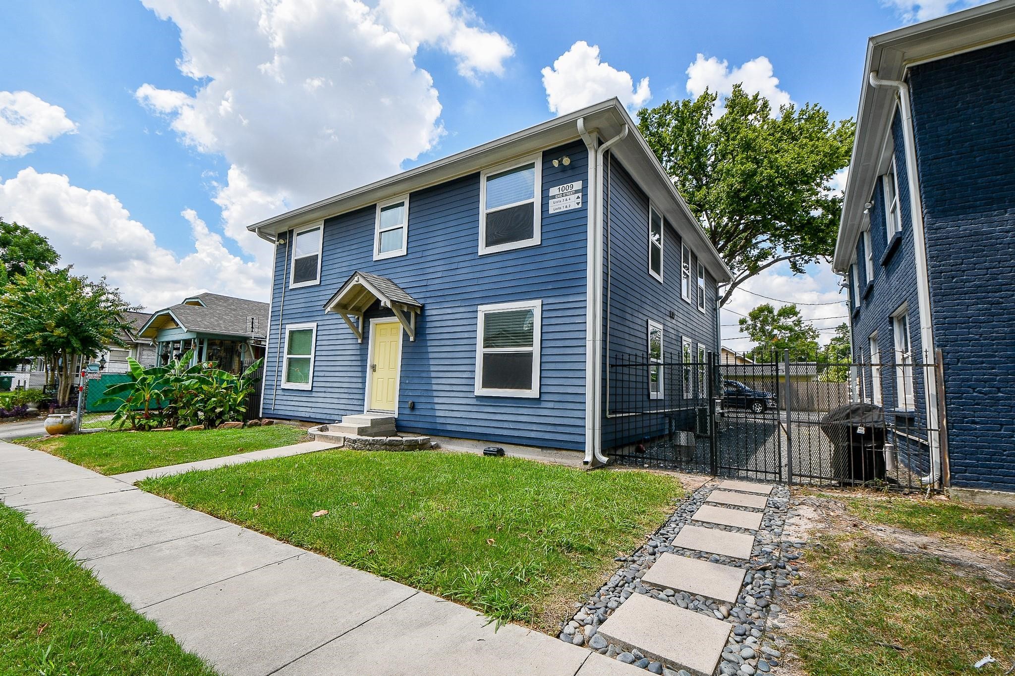 Well-maintained front yard, a side gate leading to a driveway, and a modern design perfect for family living.