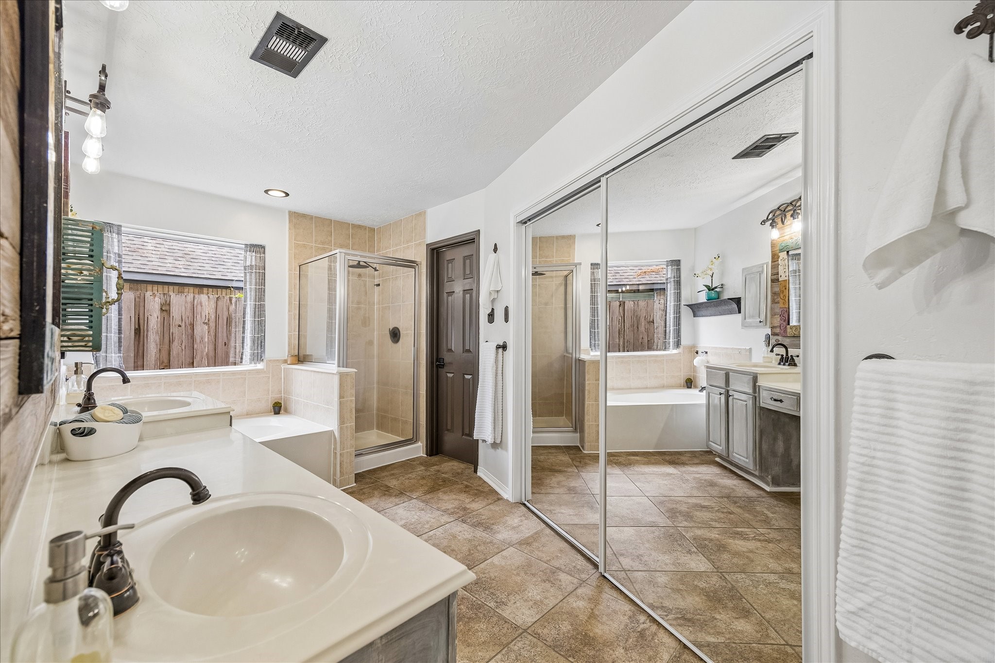 Large primary bathroom with jetted tub, separate bath/shower & toilet has a door.