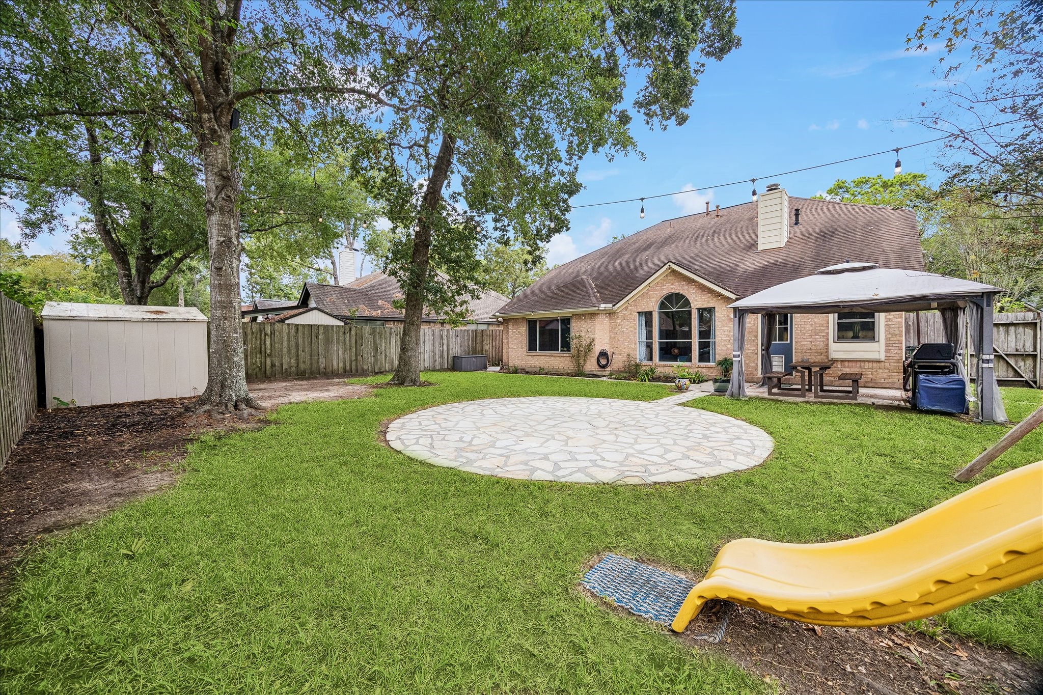 Storage shed and swing/slide set, gazebo & paver area