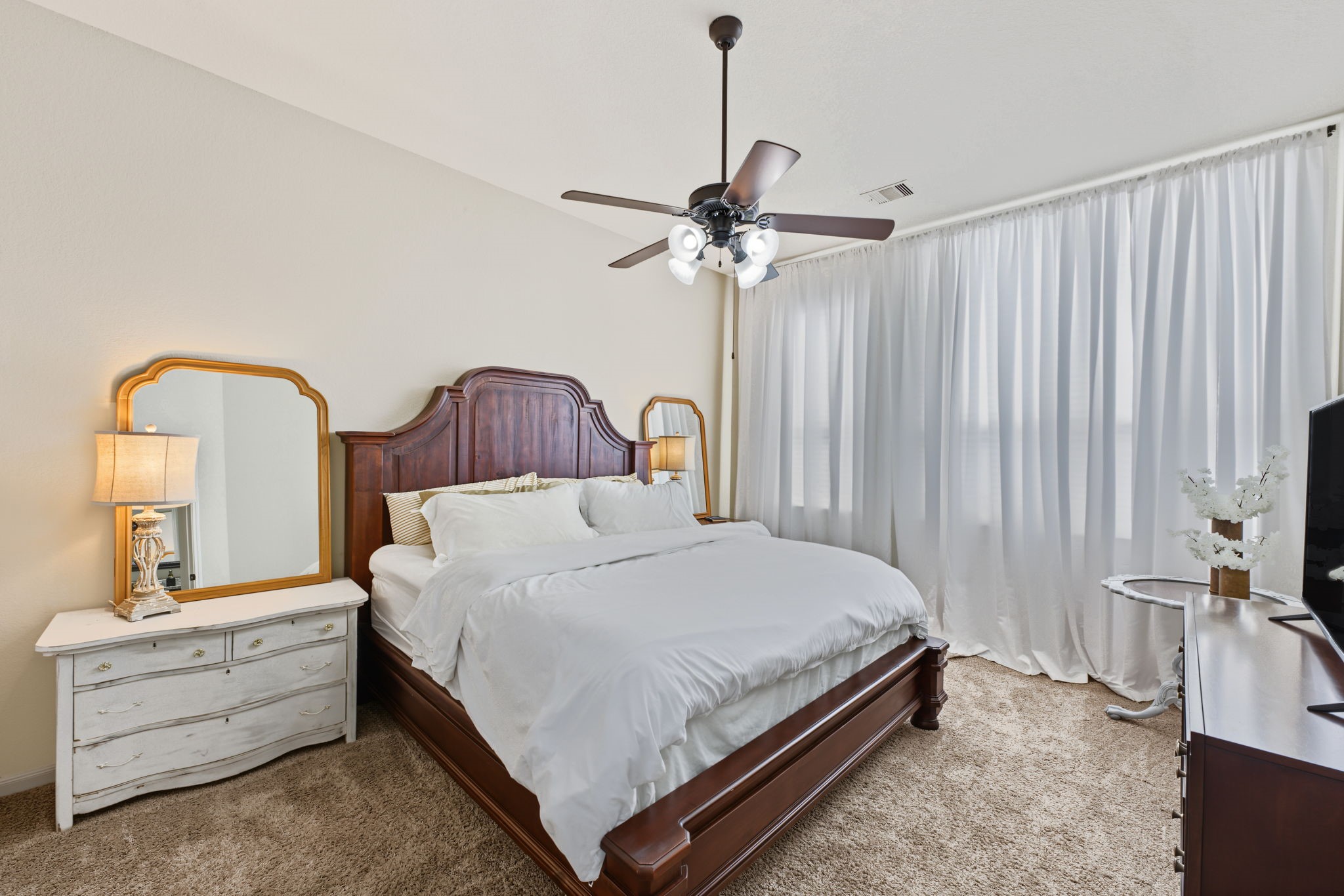 Another view of the primary bedroom with a wall of windows to let in the natural light.