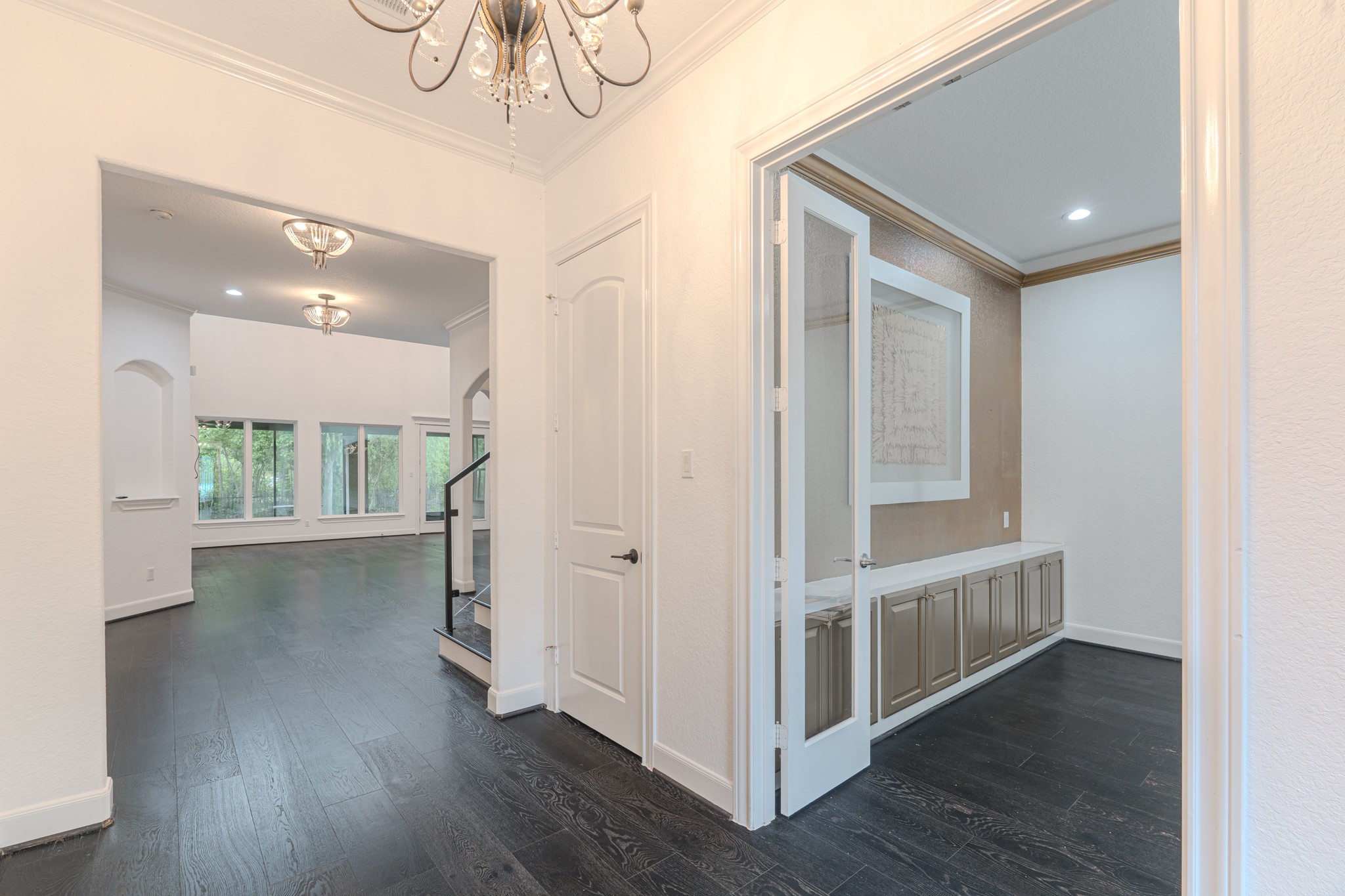 Views from the entry, coat closet, crown molding throughout, seamless engineered hardwood floors, study or home office to the right.