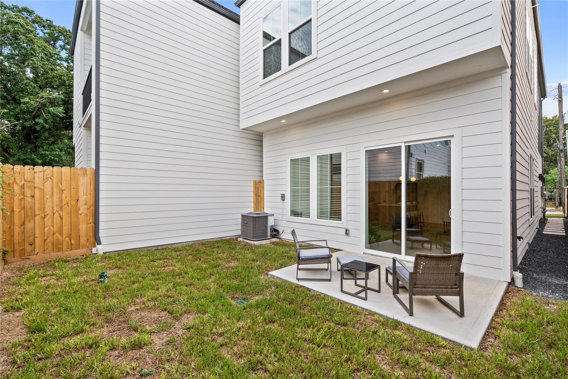 Low-maintenance green space and concrete patio providing seamless indoor-outdoor access.