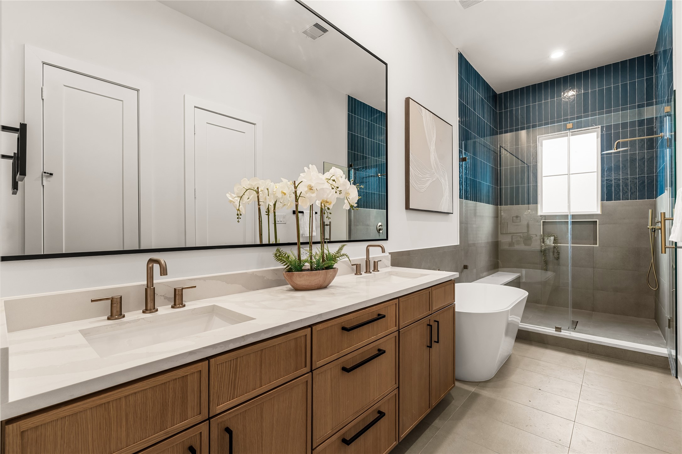 Spa-inspired primary bathroom featuring a freestanding soaking tub, frameless glass shower, and dual vanity. Spa-inspired primary bathroom featuring a freestanding soaking tub, frameless glass shower, and dual vanity.