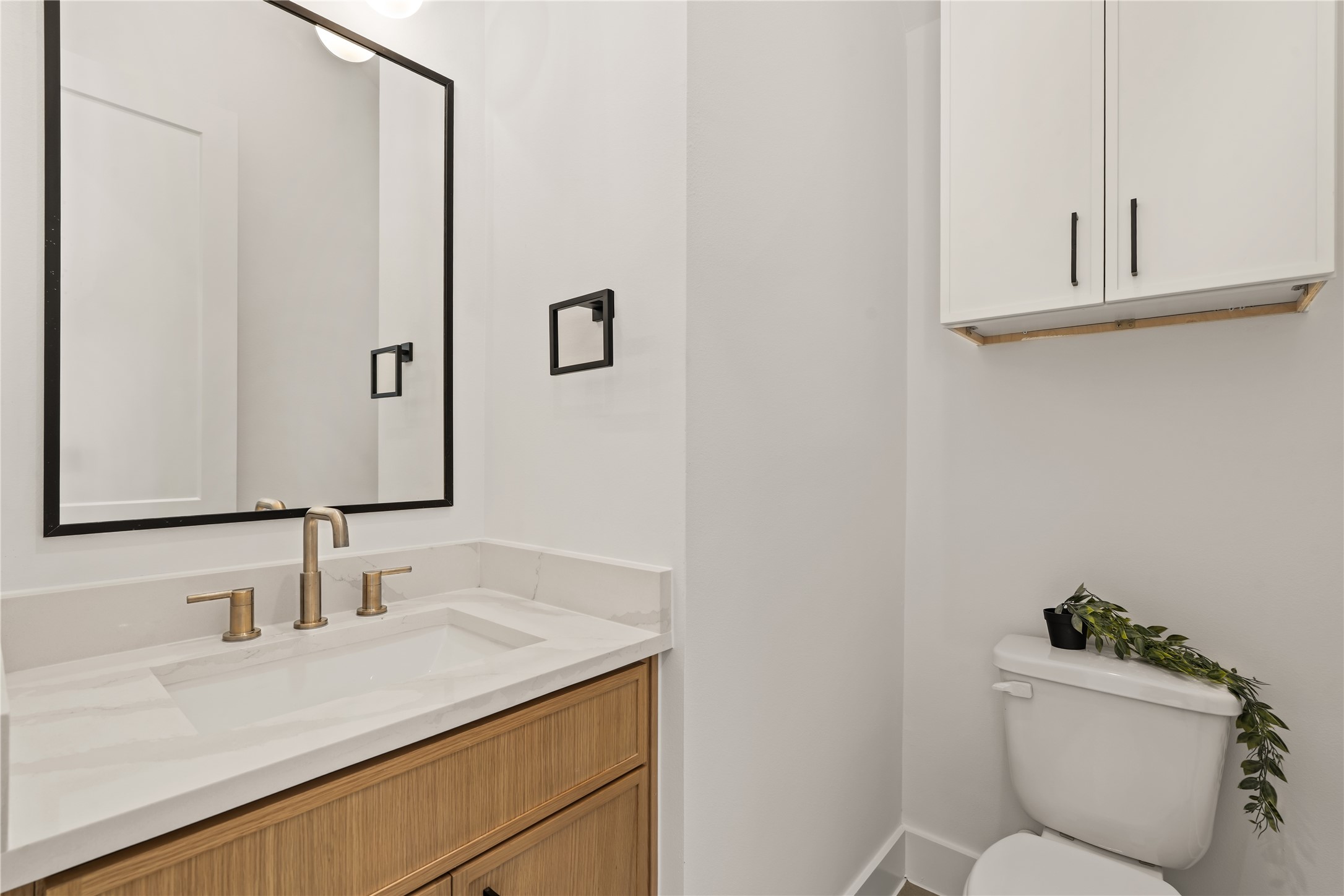 Convenient main-floor powder room complete with modern fixtures and a warm wood vanity.