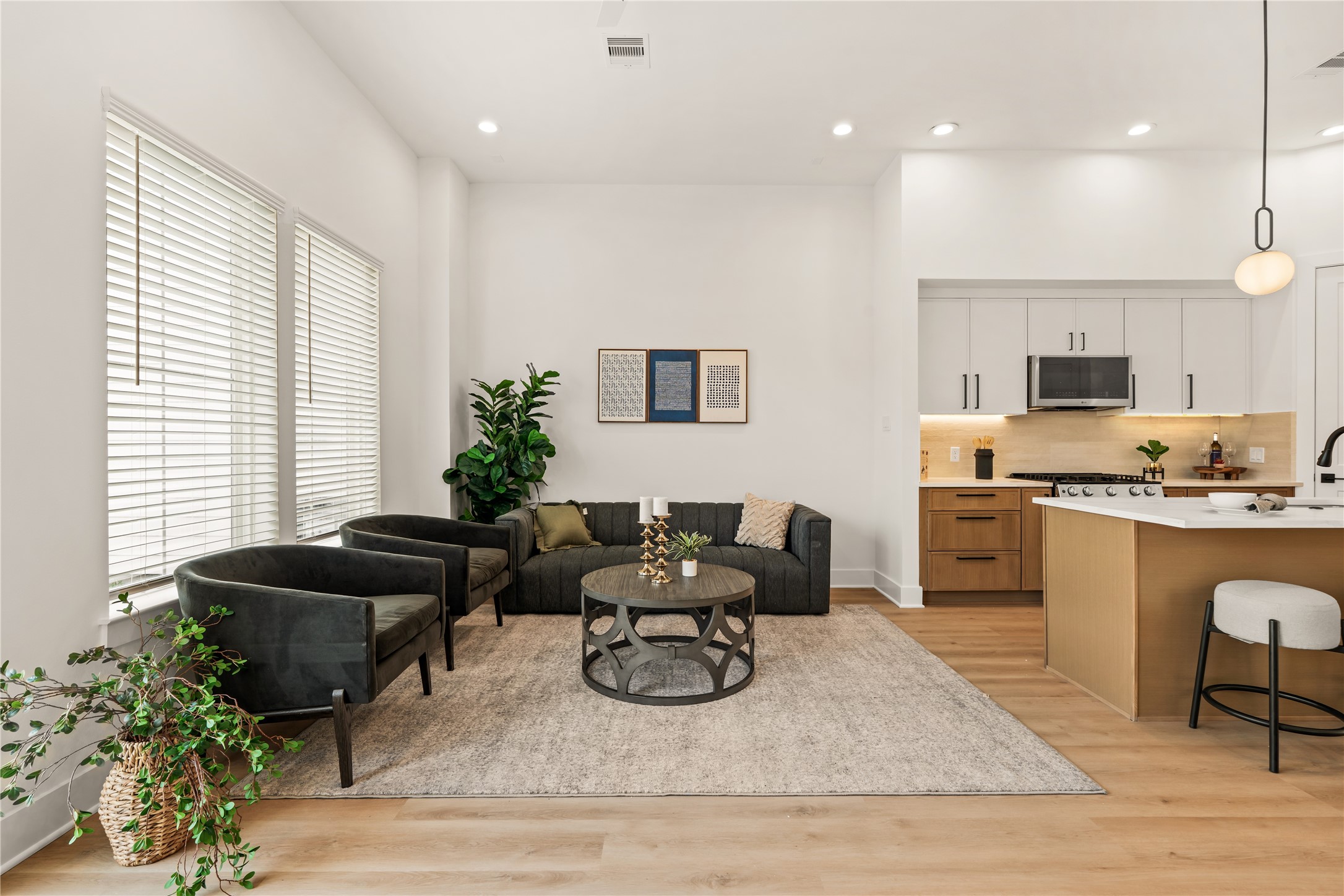 Spacious family room anchored by warm wood-look flooring and sunlit windows.