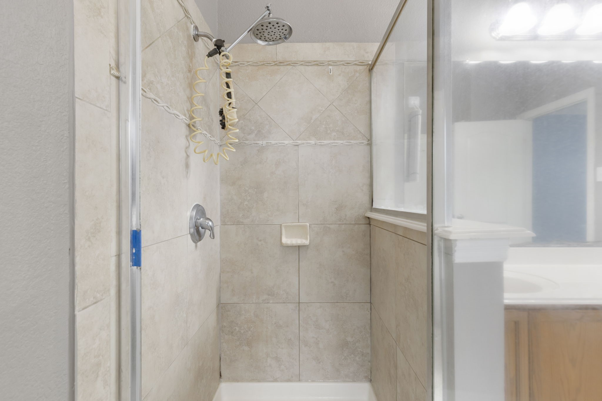 Luxurious primary bathroom featuring a sleek tiled shower and modern fixtures for a spa-like retreat.
