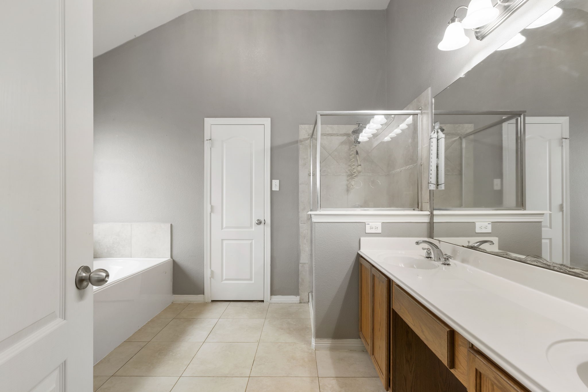 Luxurious primary bathroom featuring a sleek double vanity, spacious walk-in shower, and a relaxing jetted tub, all enhanced by elegant finishes and abundant natural light.