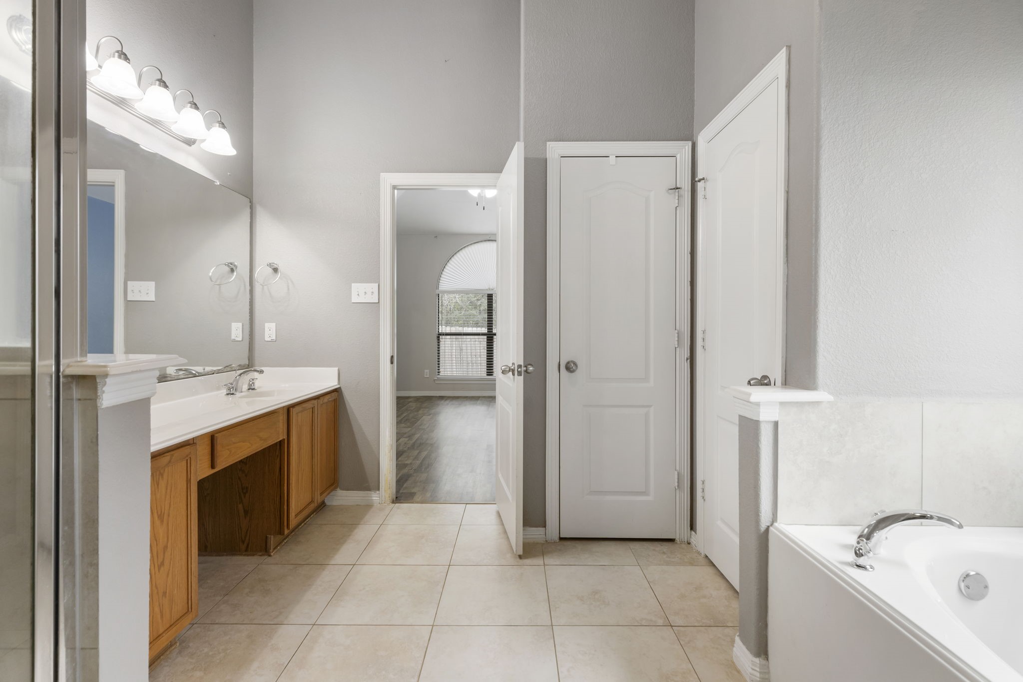 Experience luxury in the primary bathroom with its elegant dual sinks, spacious layout, and relaxing soaking tub, offering a serene retreat.