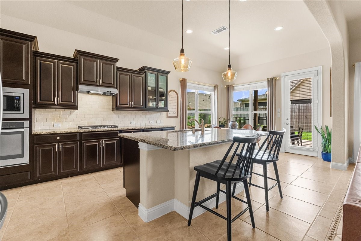 The chef-inspired kitchen with 42" cabinetry, crown molding, granite countertops, designer backsplash, stainless steel appliances, walk-in pantry, and butlers pantry.