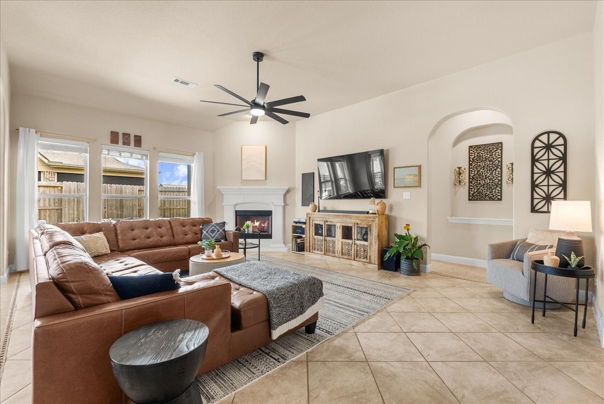 The open-concept living area features a cozy fireplace and flows seamlessly into the chef-inspired kitchen