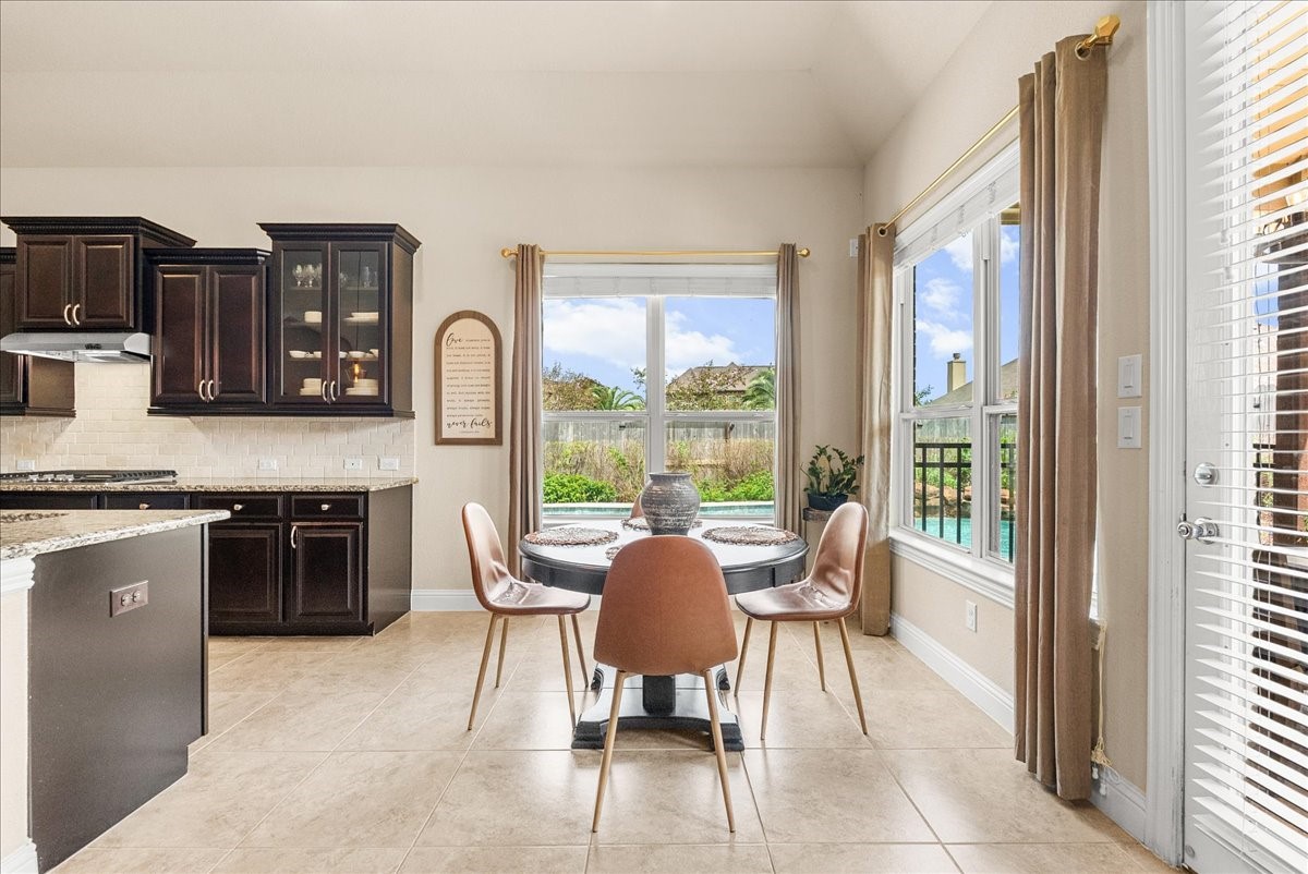 Enjoy morning coffee in the breakfast area overlooking the backyard oasis.