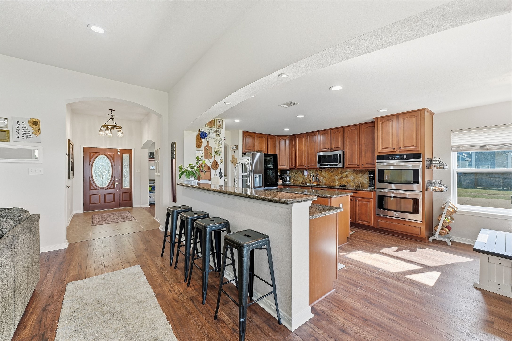 Spacious kitchen with bar seating, new LVP flooring, a 2026 LG refrigerator and a 2025 GE dishwasher.