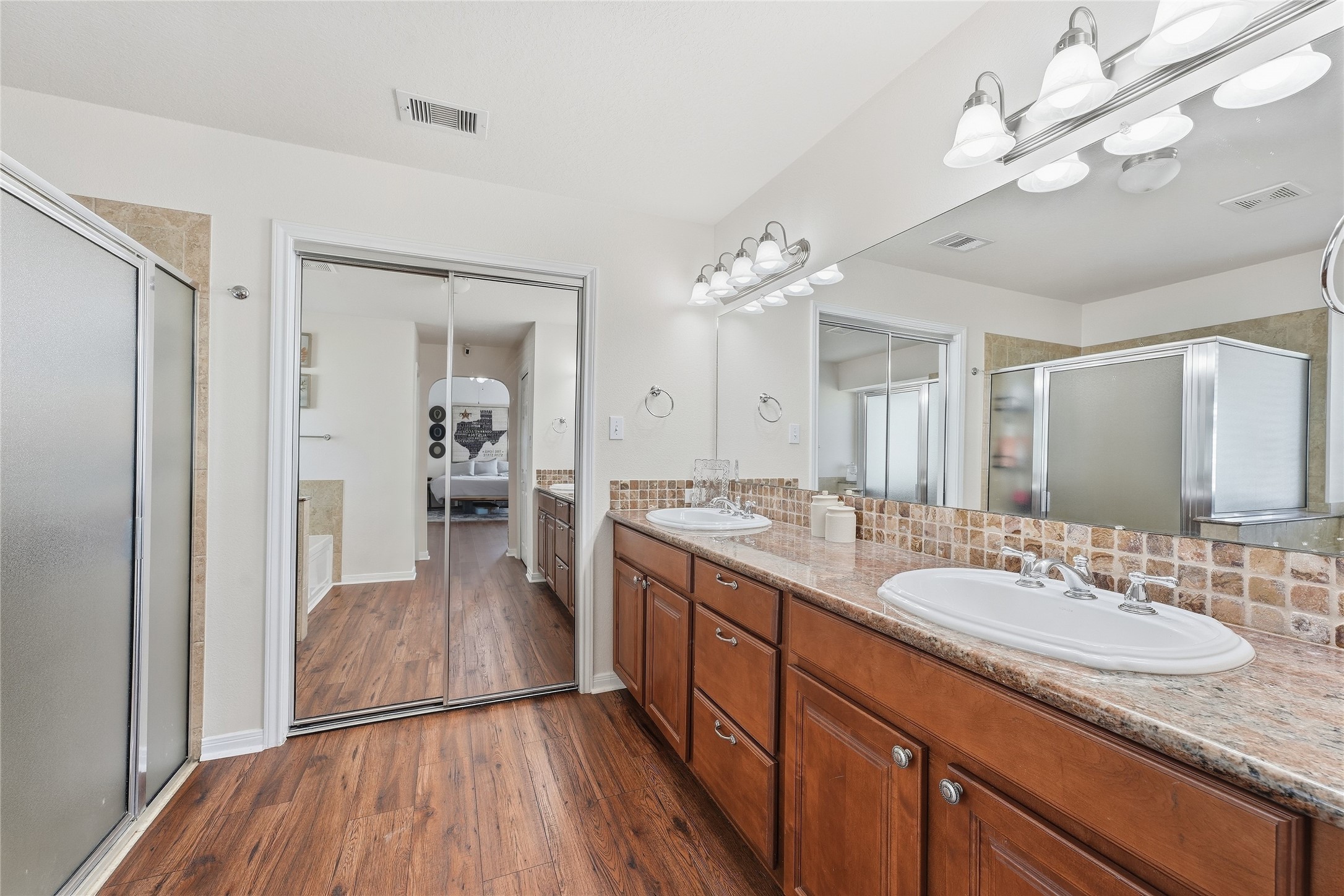The primary bathroom offers dual vanities, granite countertops, generous storage and a large walk-in closet to keep everything organized.