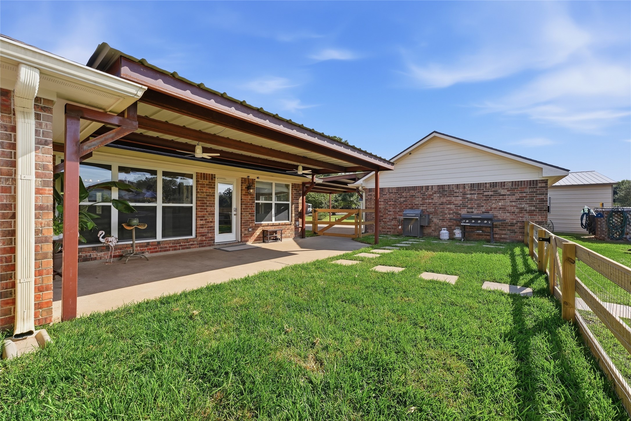 The covered patio extends your living space outdoors with a shaded seating area, while new fencing  adds privacy.