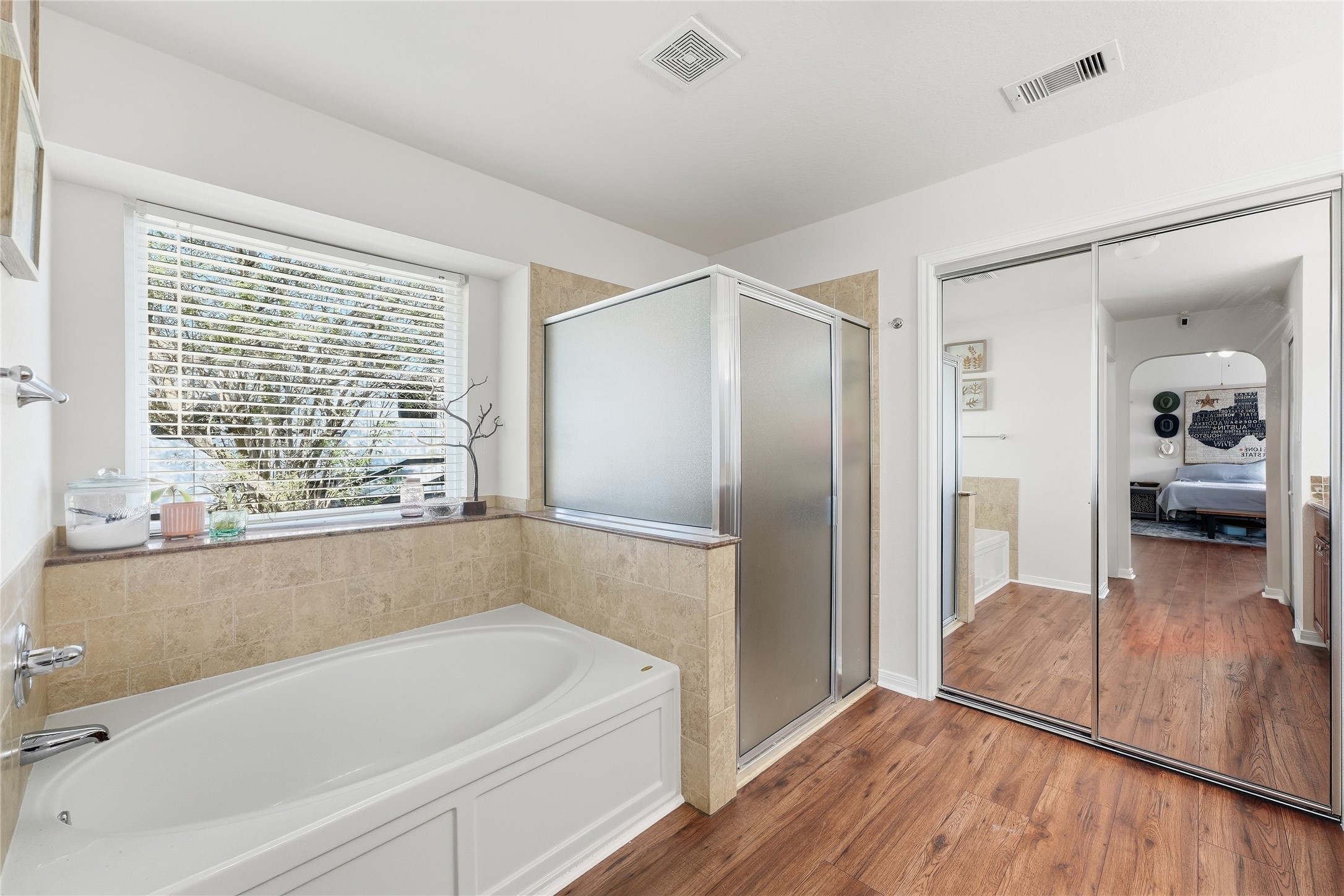 The primary bath features a separate shower and soaking tub, abundant natural light.