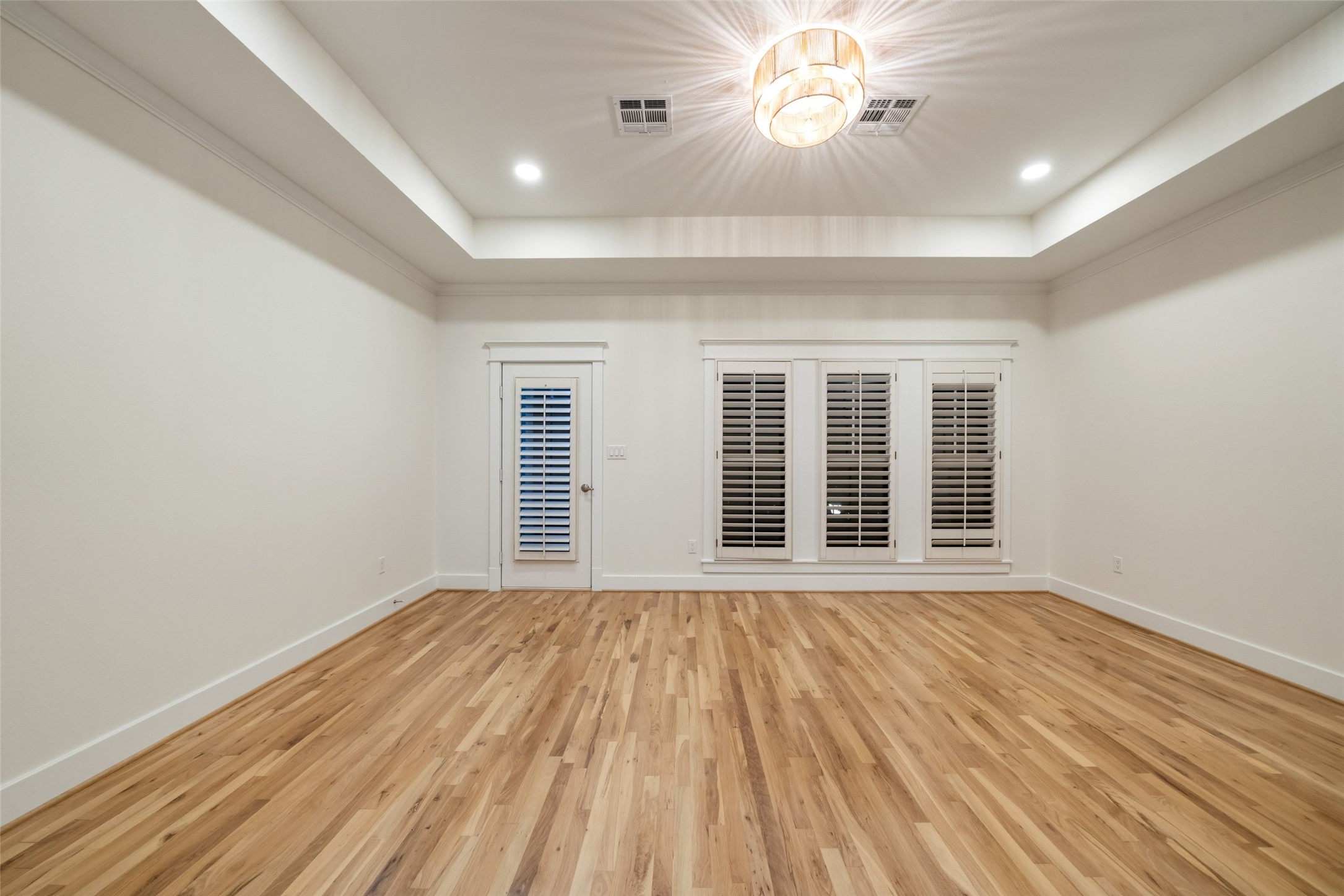 A spacious primary retreat featuring beautiful wood flooring, natural light, and a calming atmosphere.