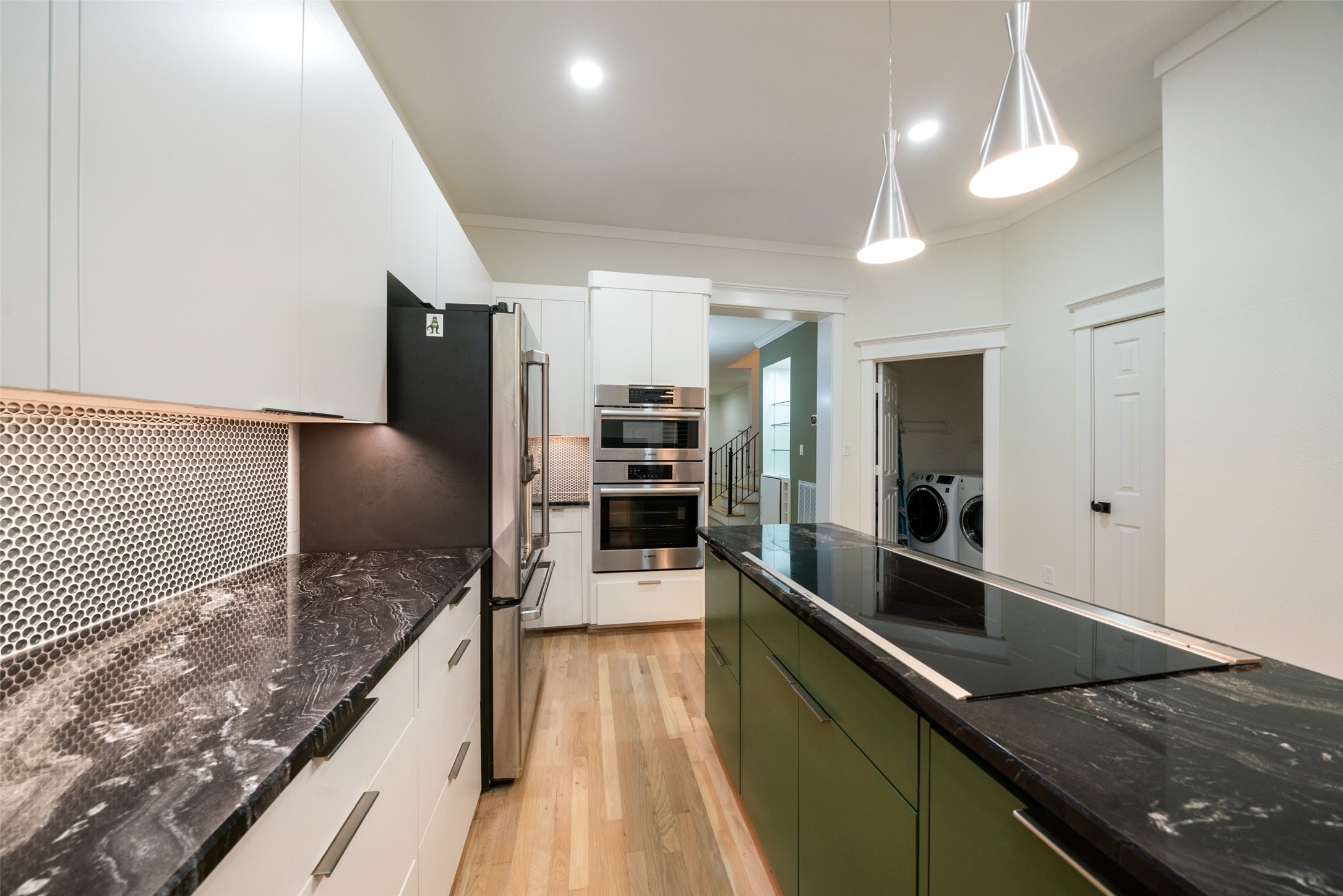 Elegant countertops and green glass tile backsplash bring subtle color and contemporary sophistication.