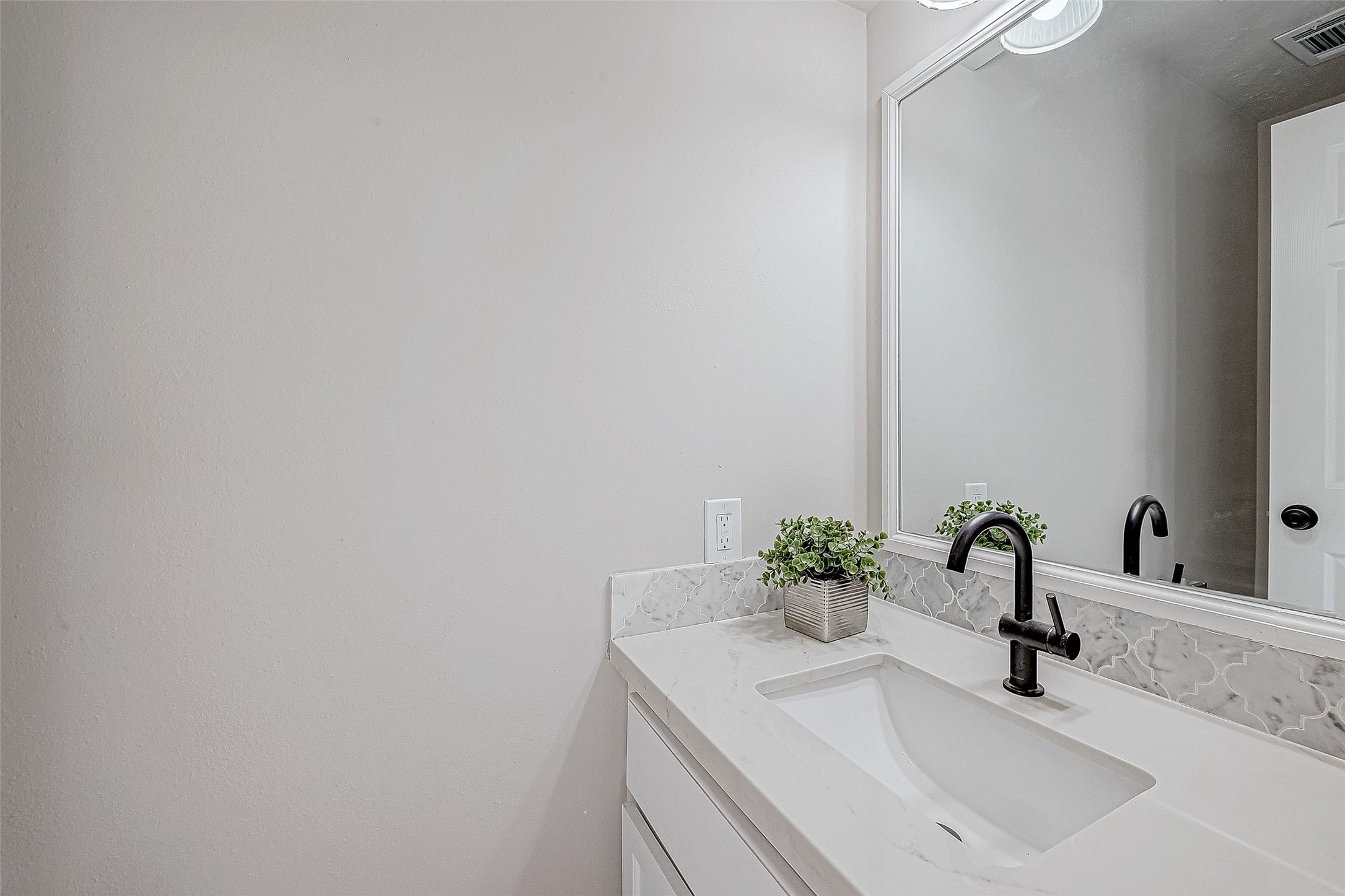 Half Bath featuring a sleek vanity with a modern faucet.