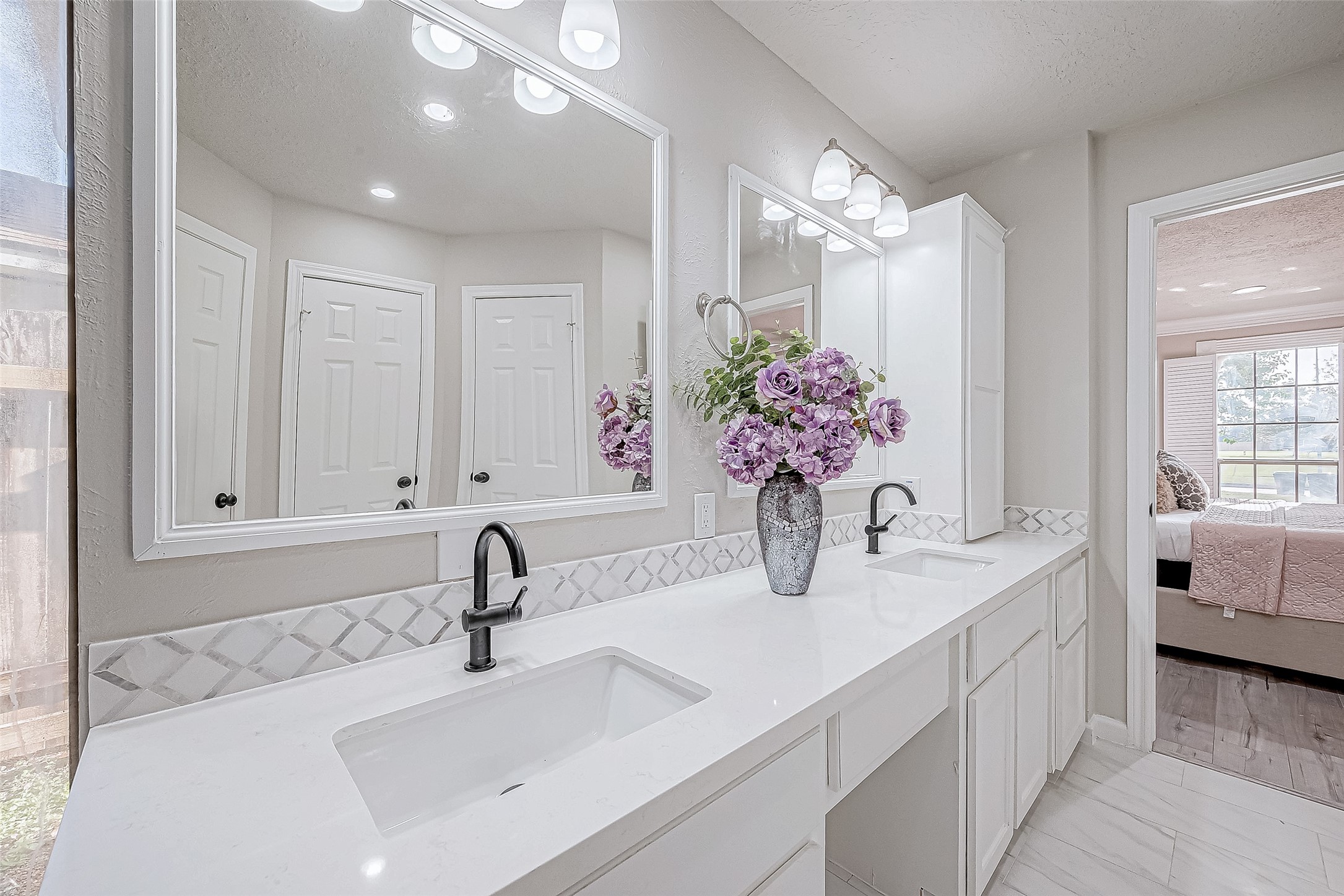 A light color palette, decorative backsplash, and ample lighting create an elegant, airy ambiance.