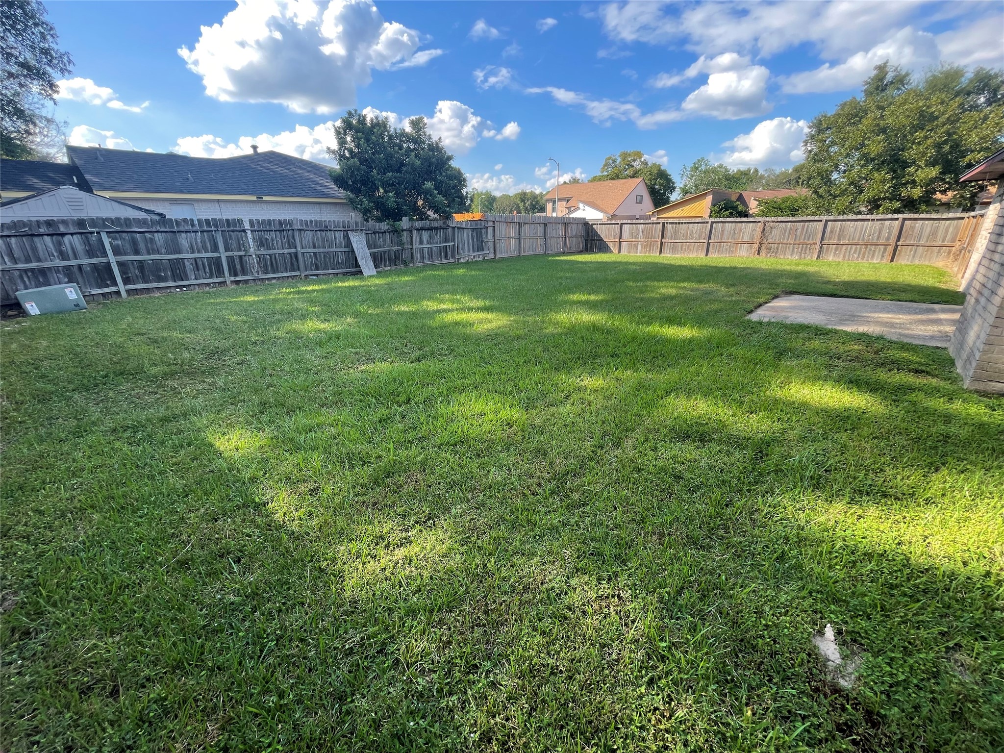 Another view of the spacious backyard showcases the lush green lawn and generous outdoor space, ideal for weekend BBQs, family gatherings, entertaining guests, or simply relaxing outdoors.