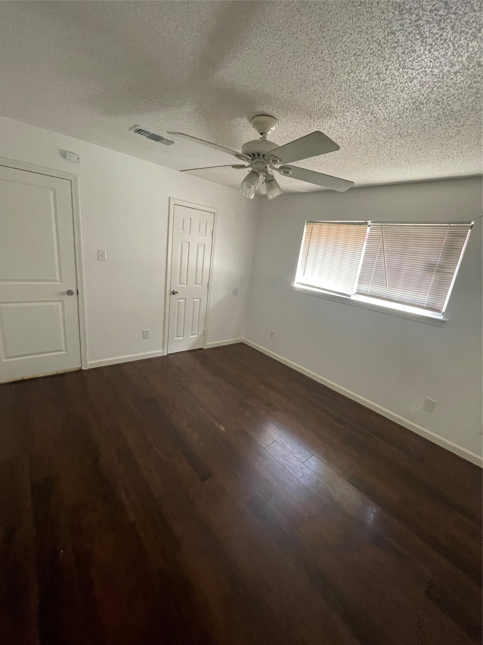 Another view of the spacious primary bedroom. This angle highlights the bedroom layout and access to the half bathroom, which connects to the full bathroom.