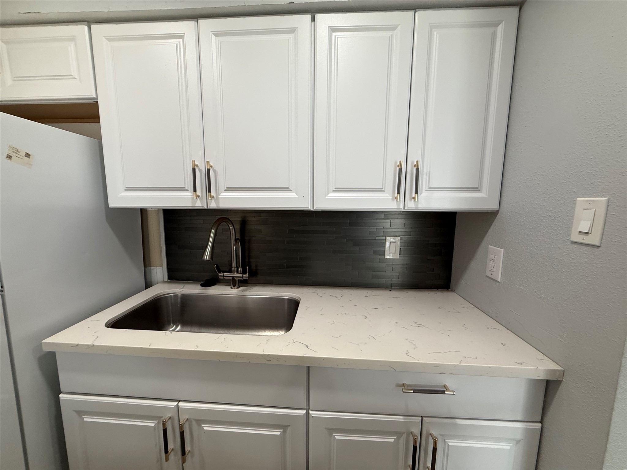 Updated backsplash, faucet and cabinet hardware.