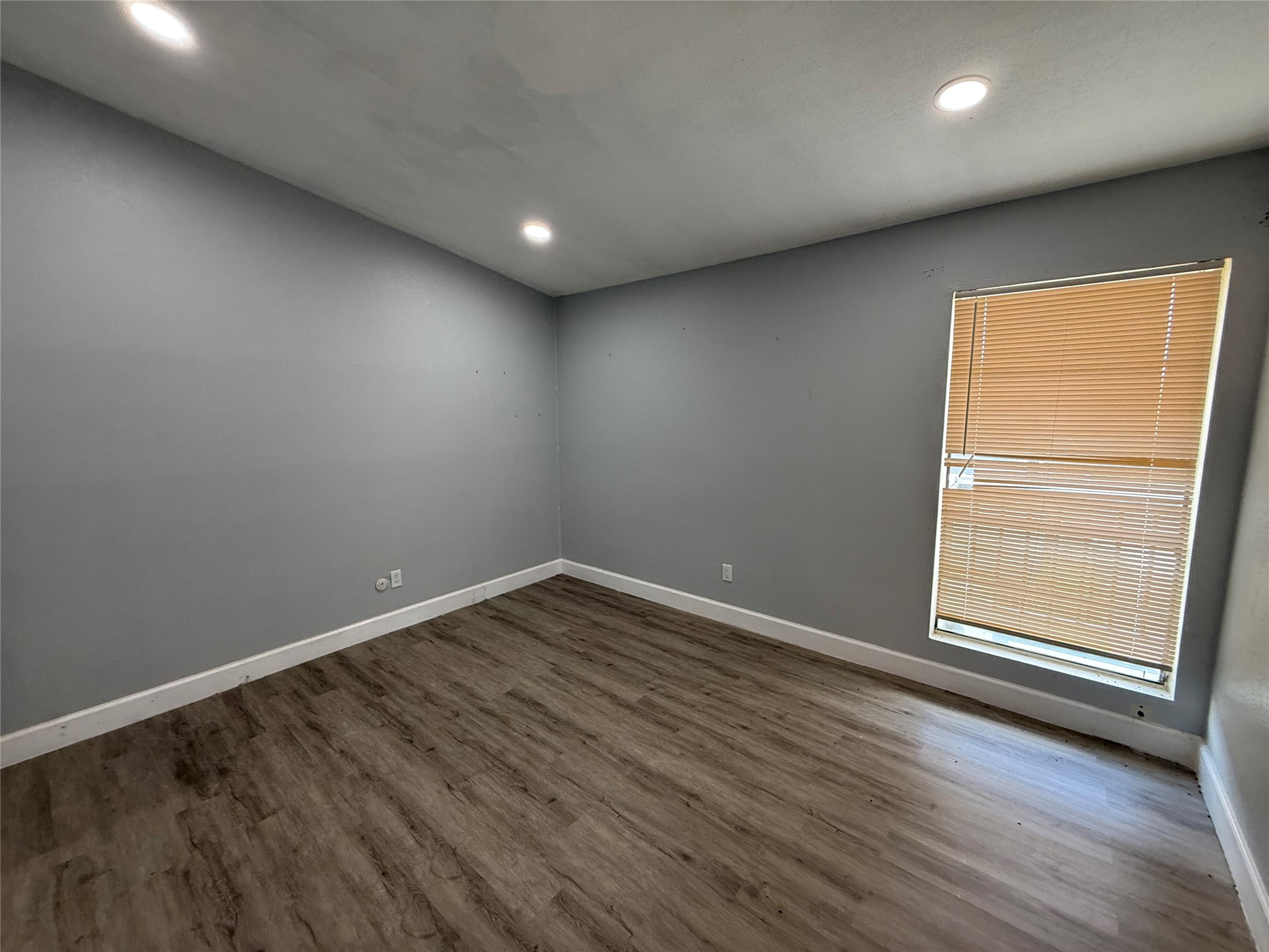 Bedroom with recessed lighting and window overlooking the courtyard.