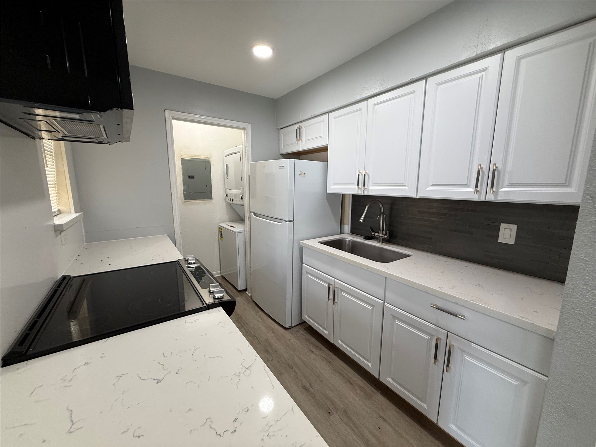 Kitchen has been updated with quartz countertops and new range and microwave. You can see the laundry space tucked away behind the kitchen. Kitchen has been updated with quartz countertops and new range and microwave. You can see the laundry space tucked away behind the kitchen.