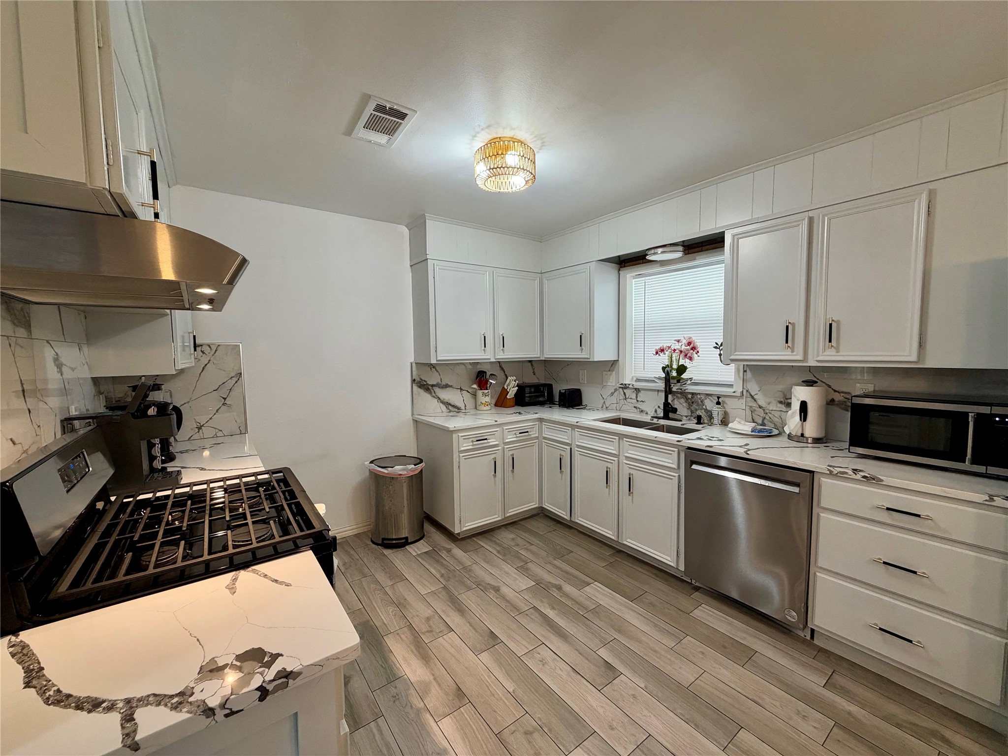 Open kitchen has been updated with freshly painted cabinets, newer appliances, and beautiful tile flooring.