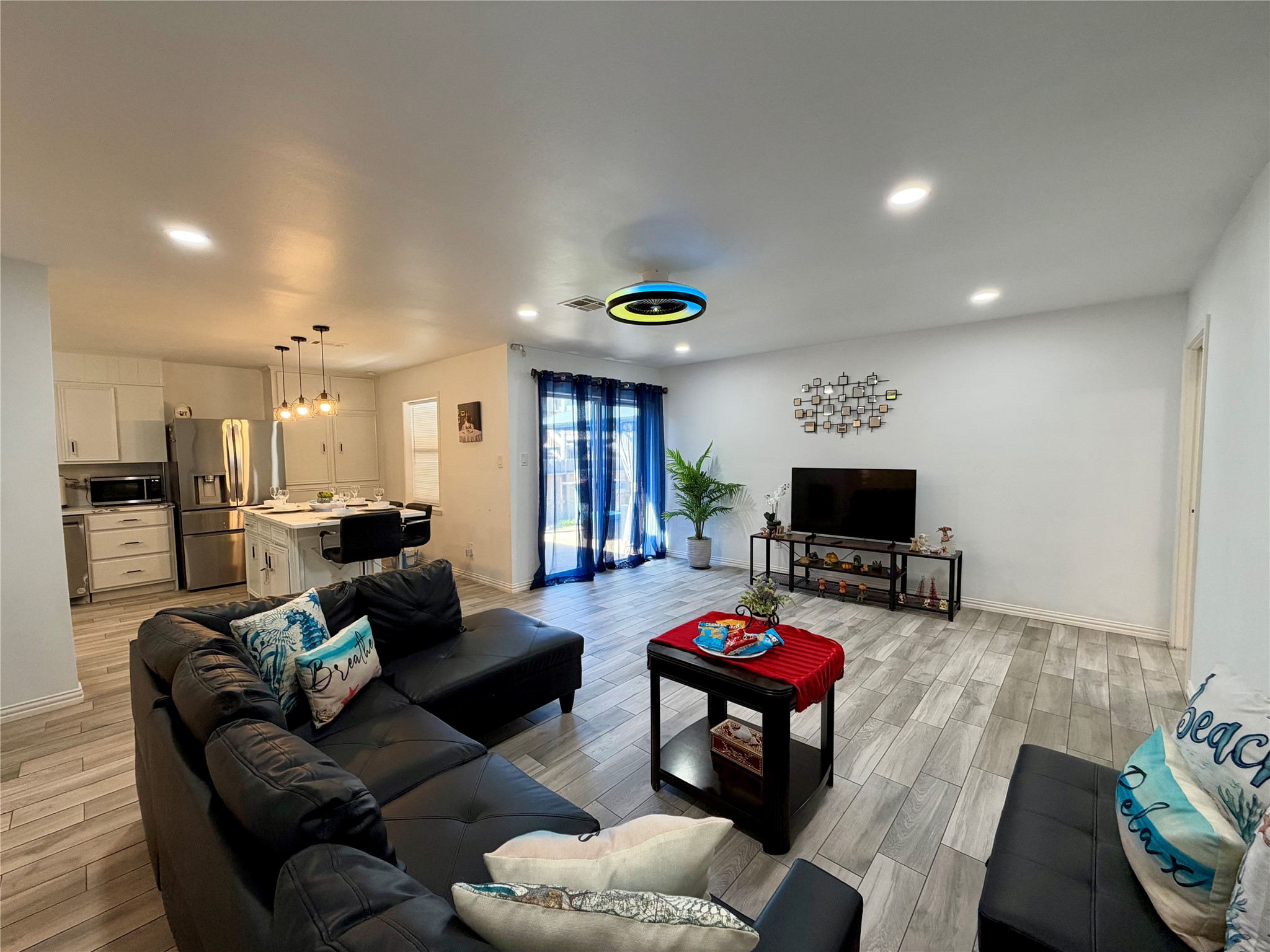 Open living space with patio access. Check out the lighted ceiling fan!