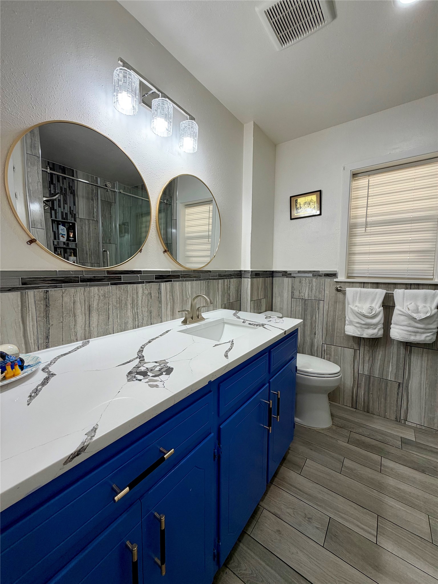Large vanity space and double mirrors. Low-maintenance tiled floors and walls and freshly painted cabinets.