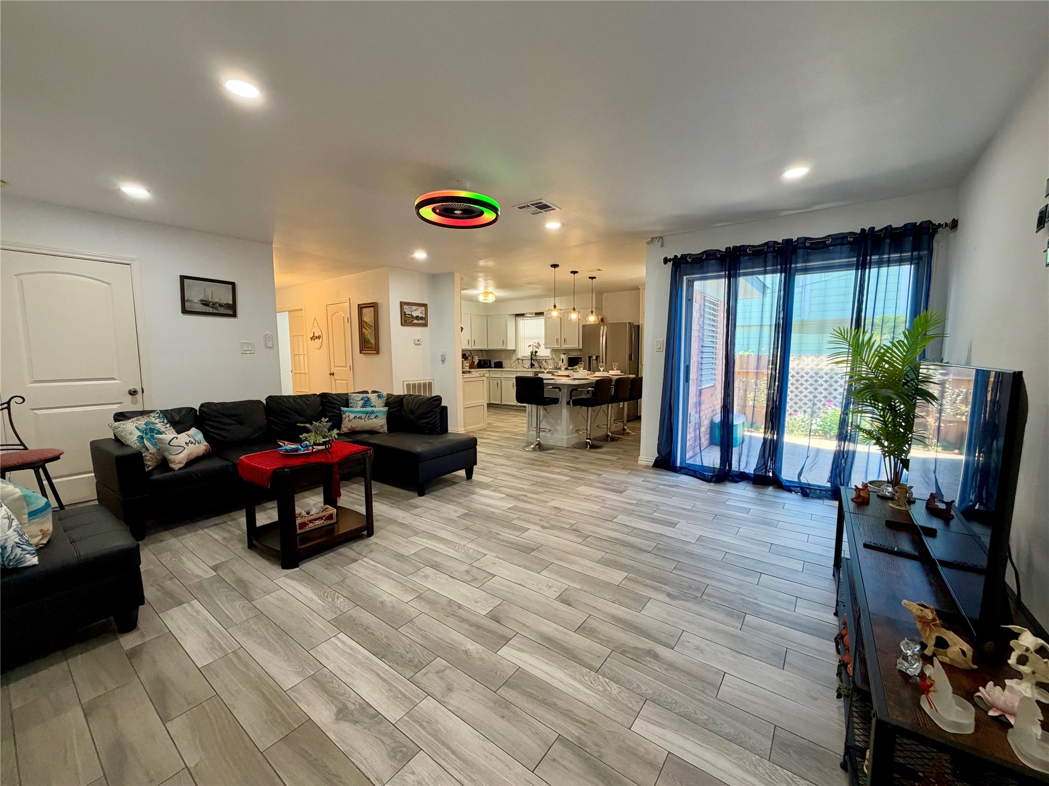 Large living space with patio access. Yes, the ceiling fan light changes colors! Garage access through the door on the left.