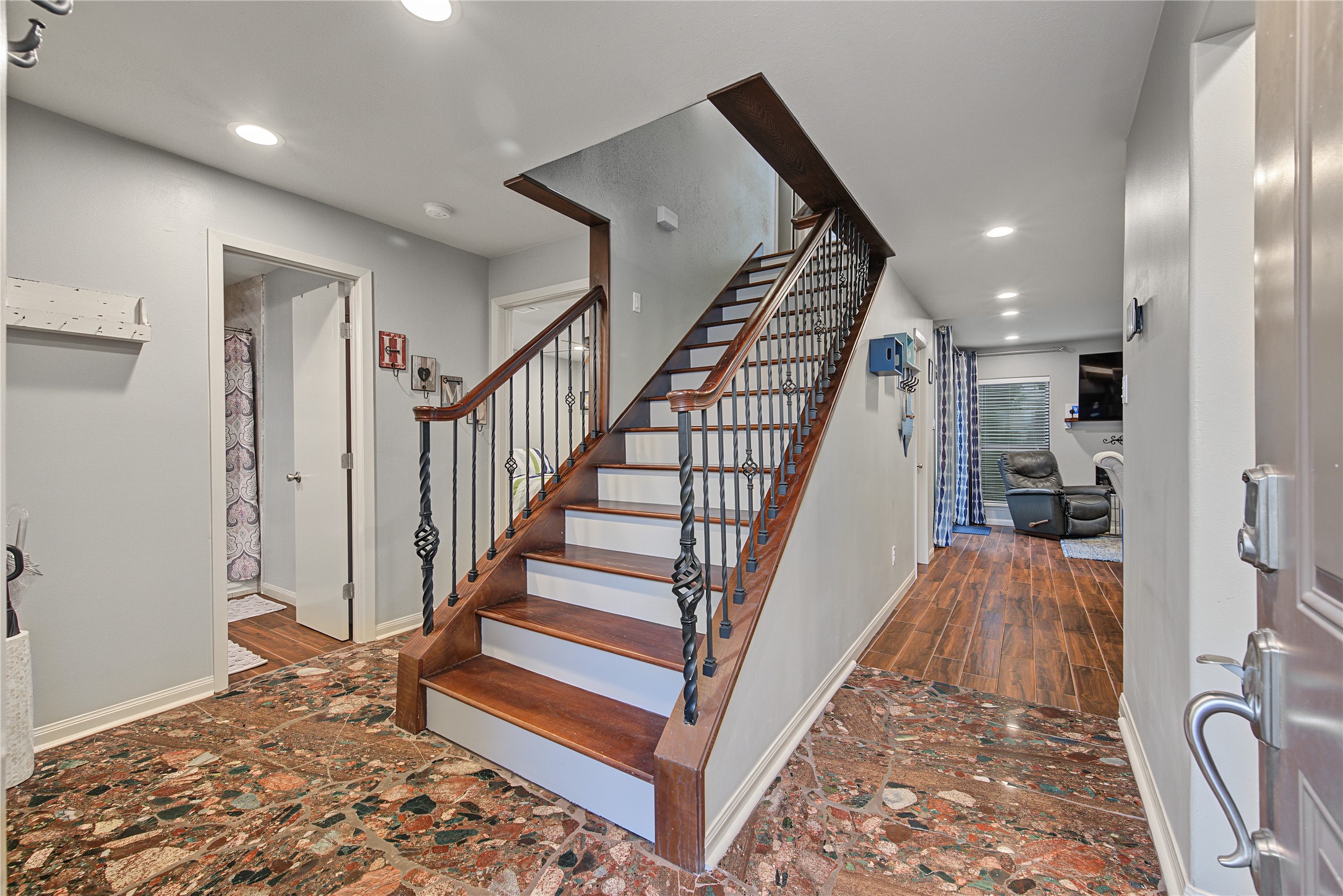Entry foyer featuring wood staircase and decorative tile flooring.